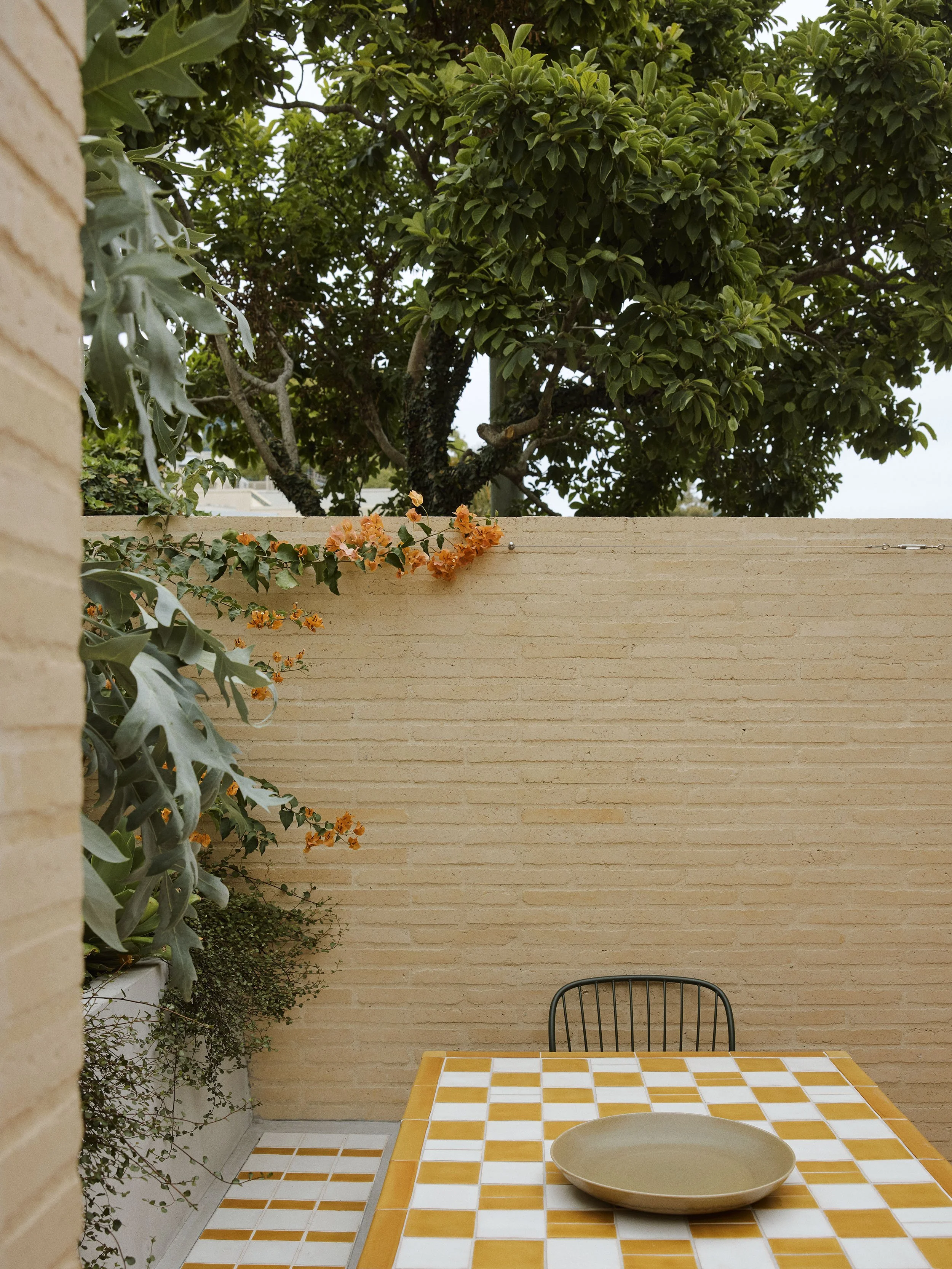 Tiled outdoor table and tiled outdoor stools and built-in concrete seat with terracotta tiles with maxi-grout in Sydney terrace renovation by heritage architects Sydney Muci.