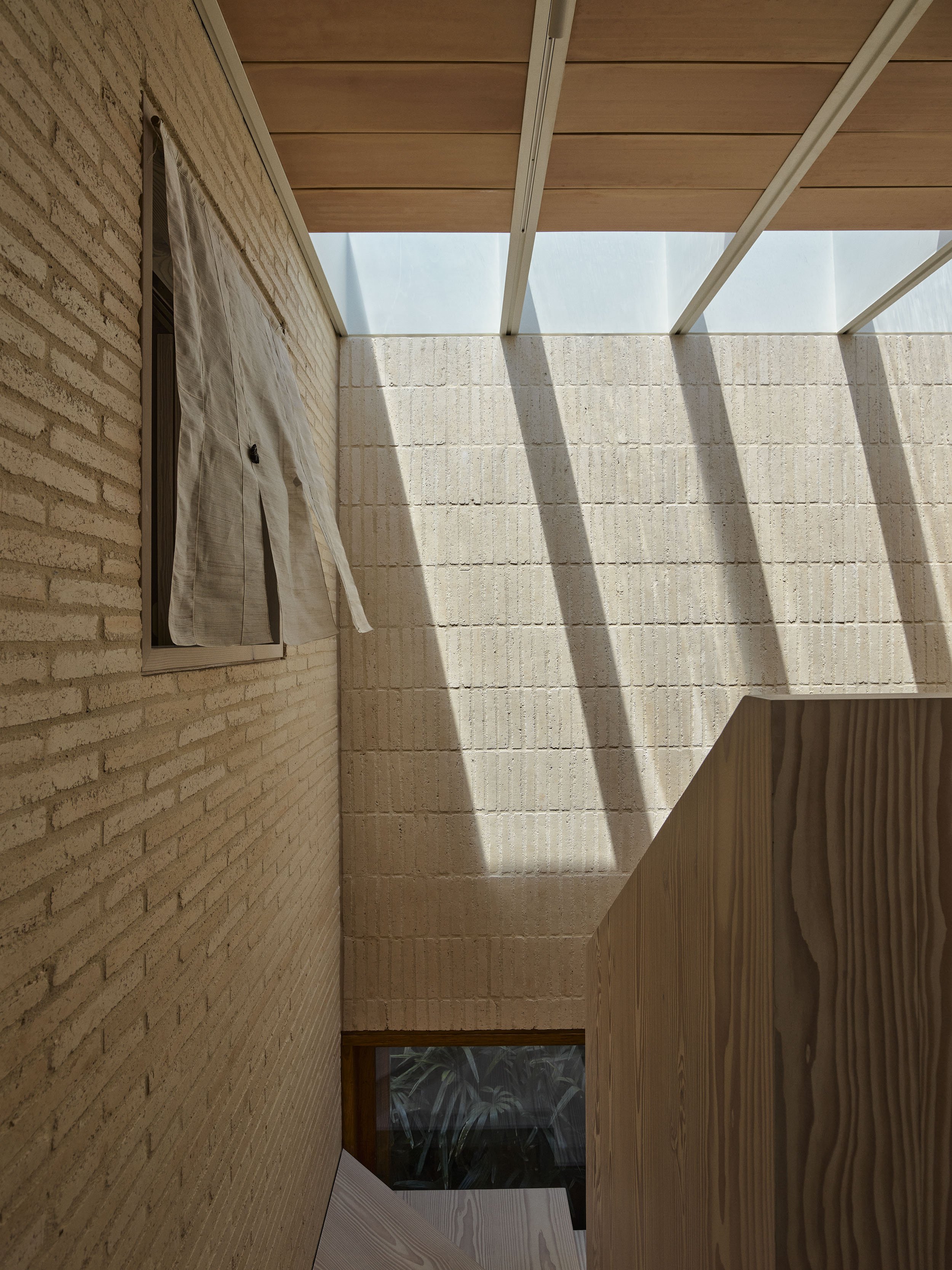 The skylights in the light well at Sydney terrace renovation, Clay House, by Muci architects. Light highlights texture of cream brick feature wall.
