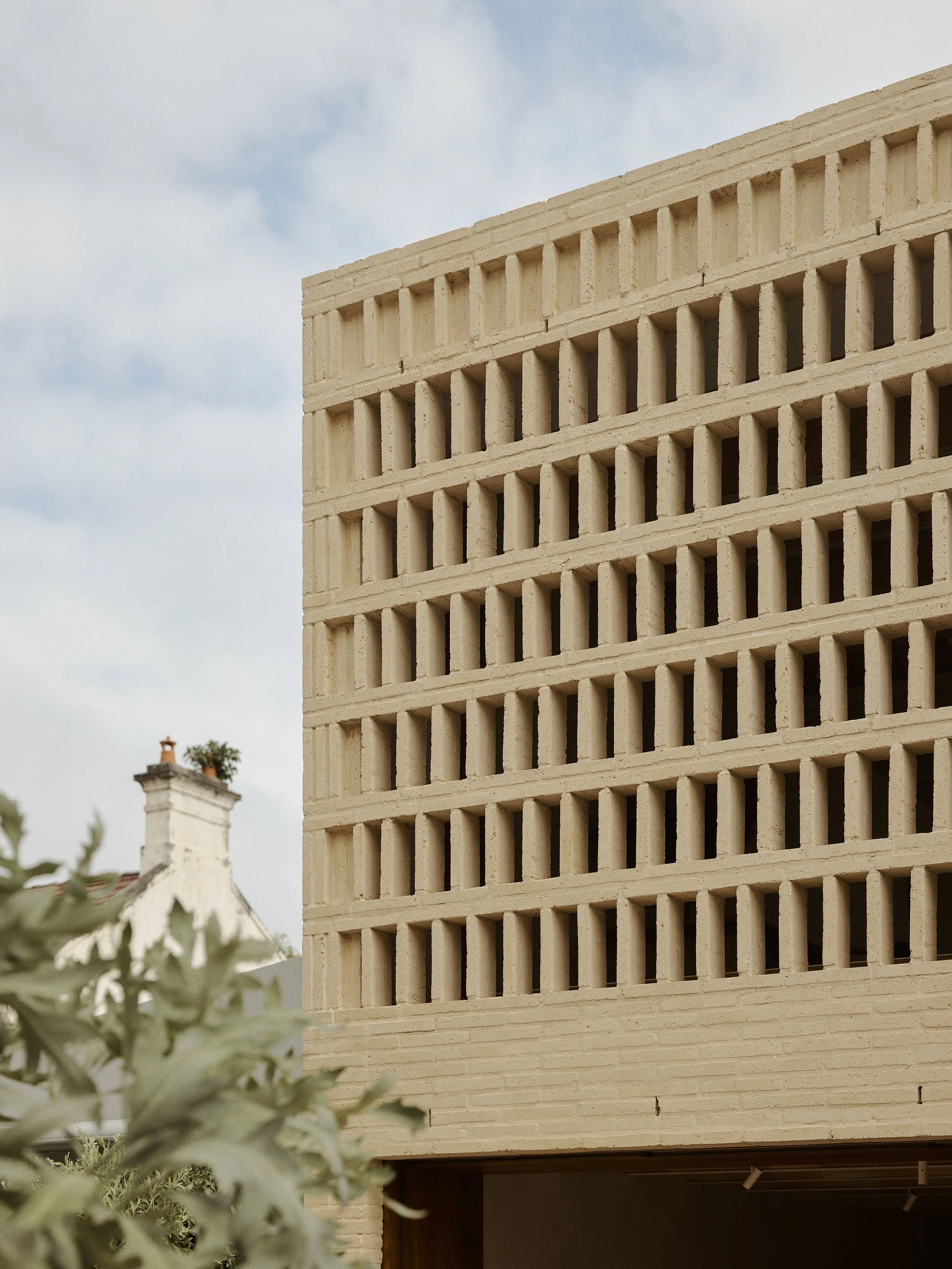 A detail of the brick screen of Clay House by architect in Newcastle, Muci. Cream bricks are stacked to create a continuous privacy screen.