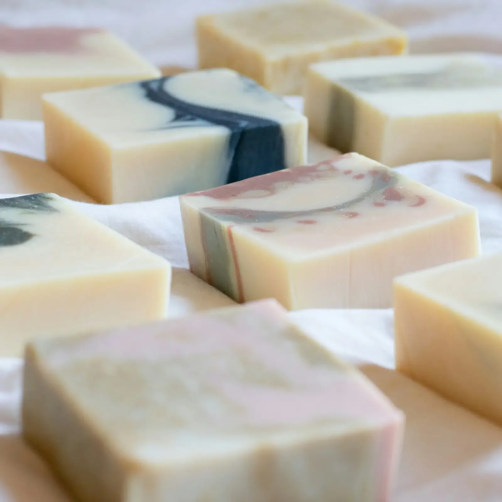 Assorted handmade soap bars with marbled colors displayed on a white surface.