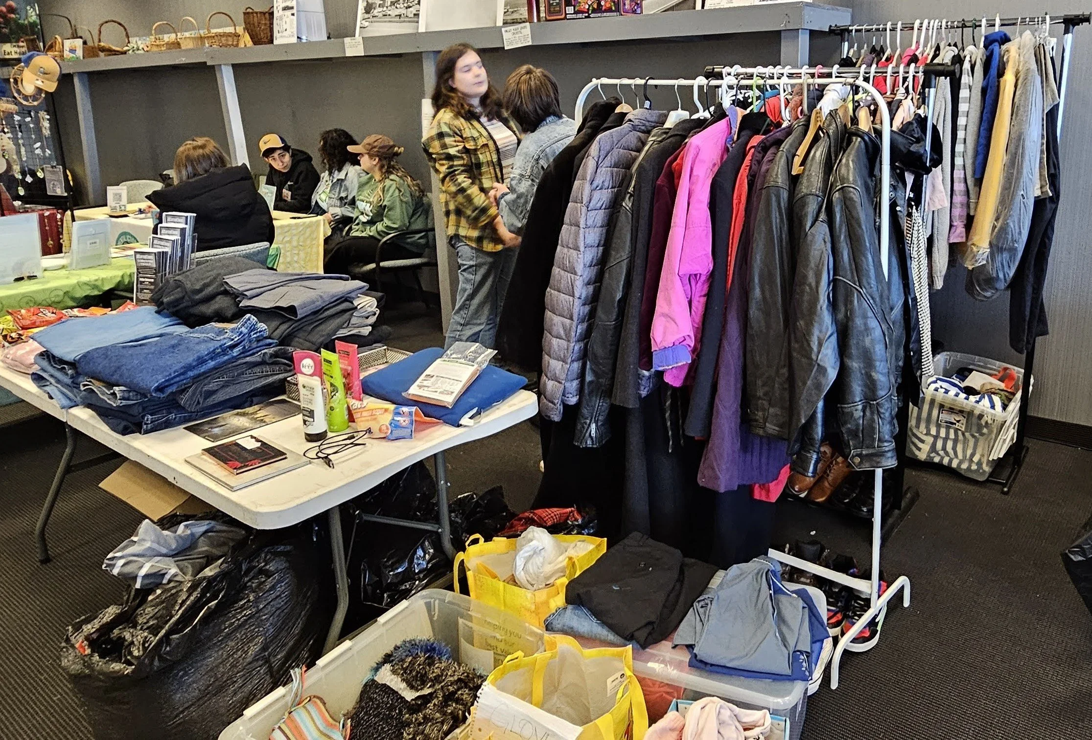 A free store setup with clothes on racks and tables of folded items.