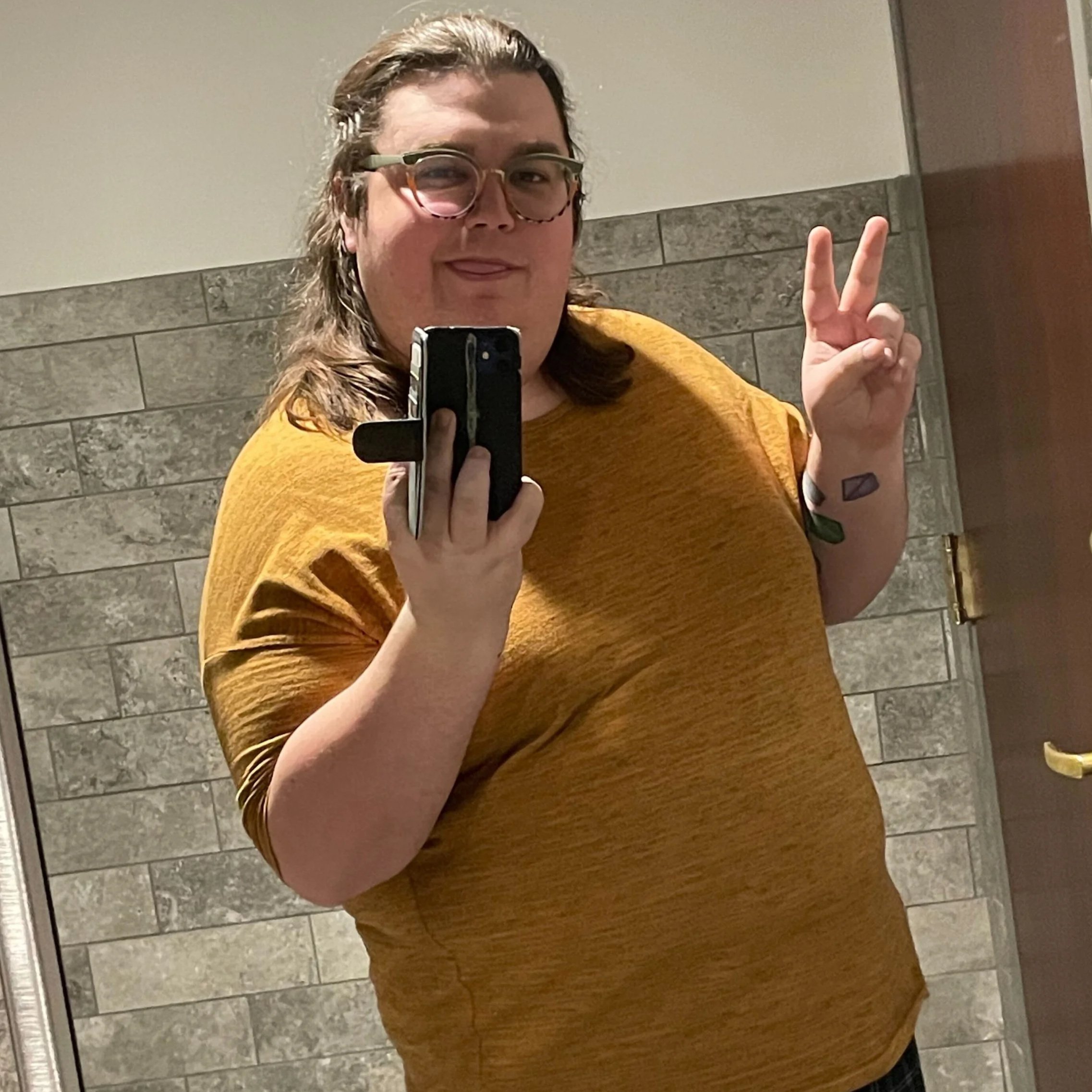 A person with a head made of green grass, wearing a white baseball cap and a beige polo shirt against a blue background.