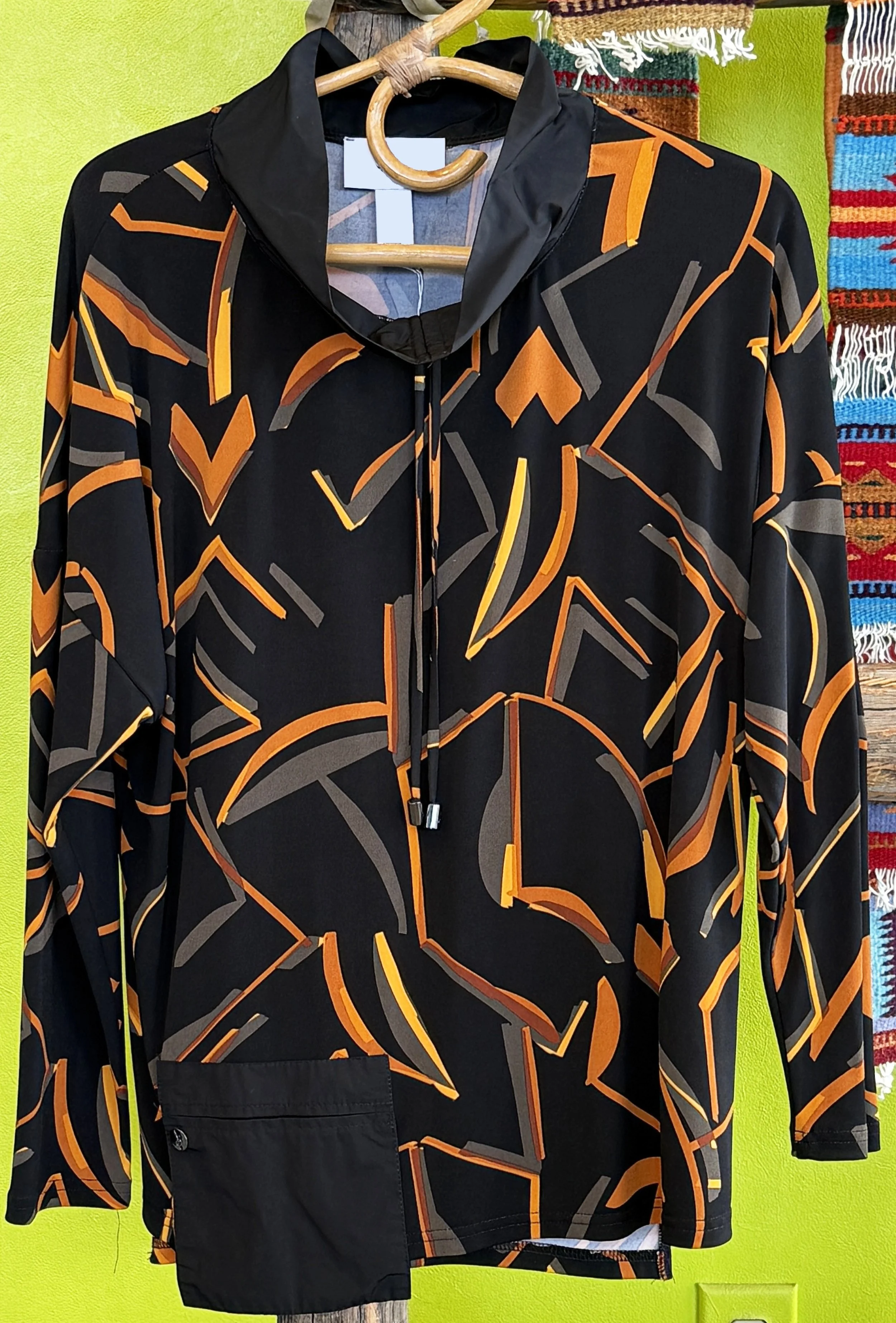 A colorful lightweight jacket in a lively Bohemian style with a patterned scarf in the background.