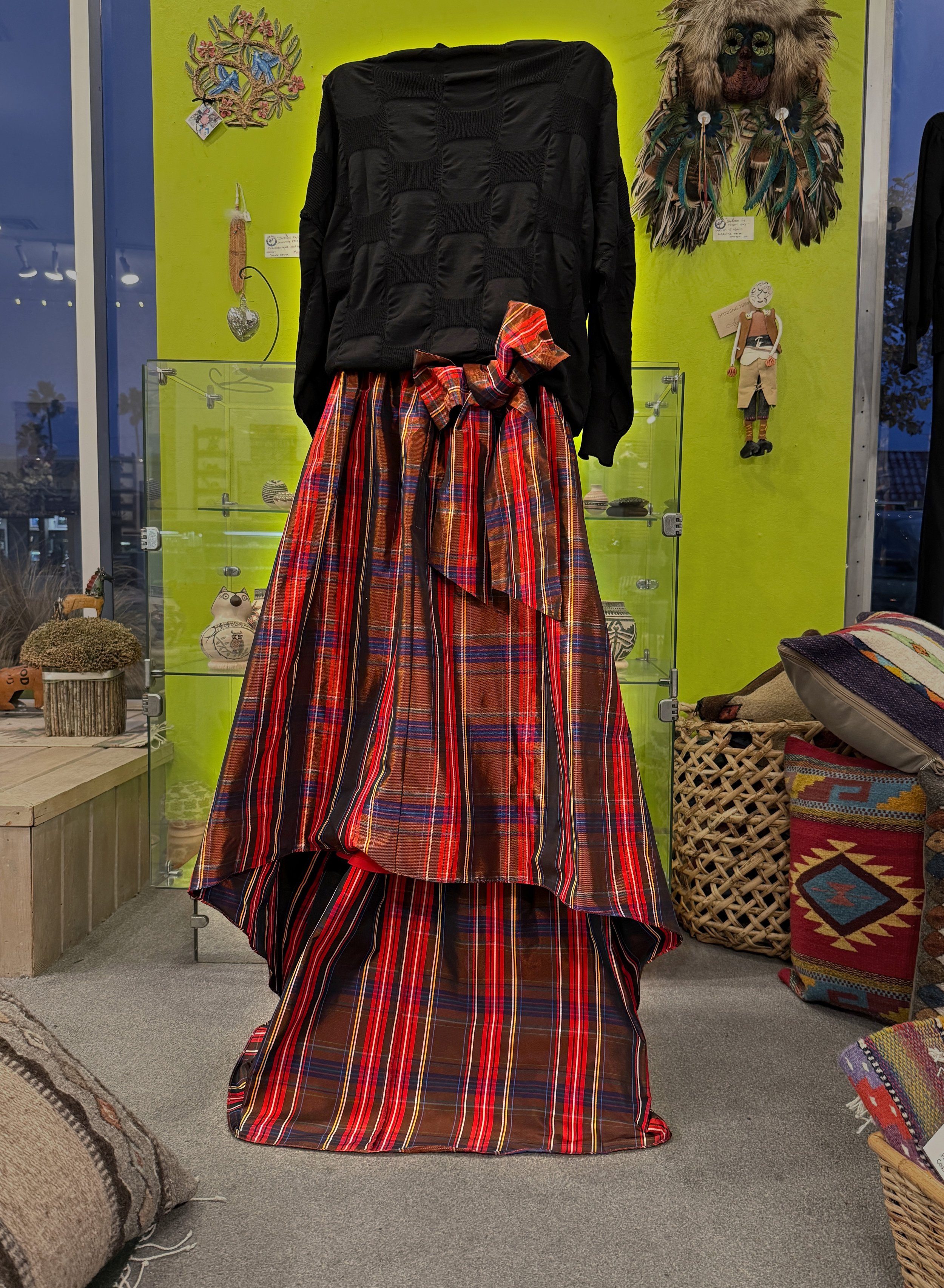 A handcrafted plaid red skirt with a bow, among the artisan clothing sold by Moon Dancer in Redondo Beach.