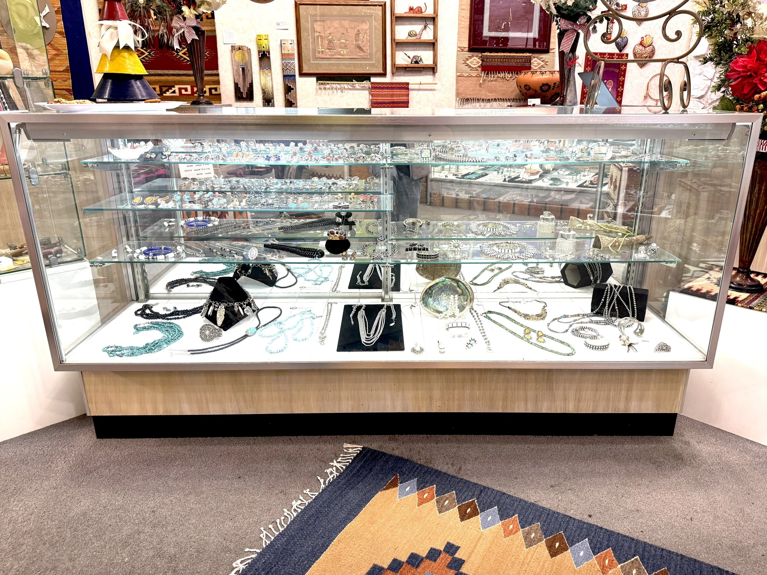 Display case filled with jewelry including necklaces, bracelets, rings, and earrings at a jewelry store, Moon Dancer in the South Bay of Los Angeles.
