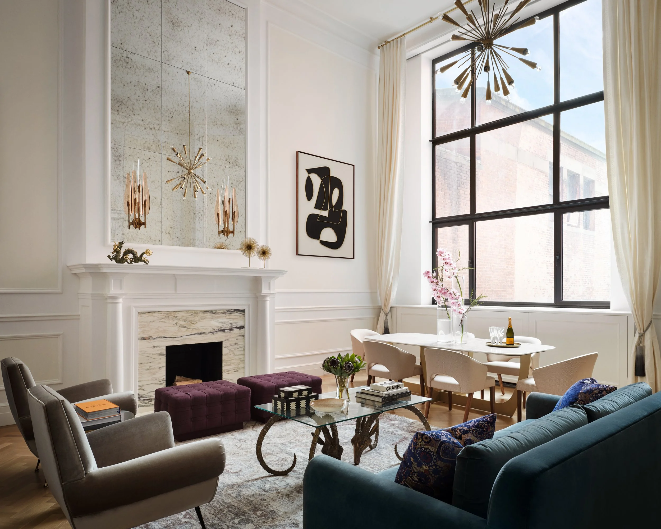 A refined Upper West Side living room with a custom marble mantel, layered seating, and an adjoining dining area designed by Michele Bitter Designs