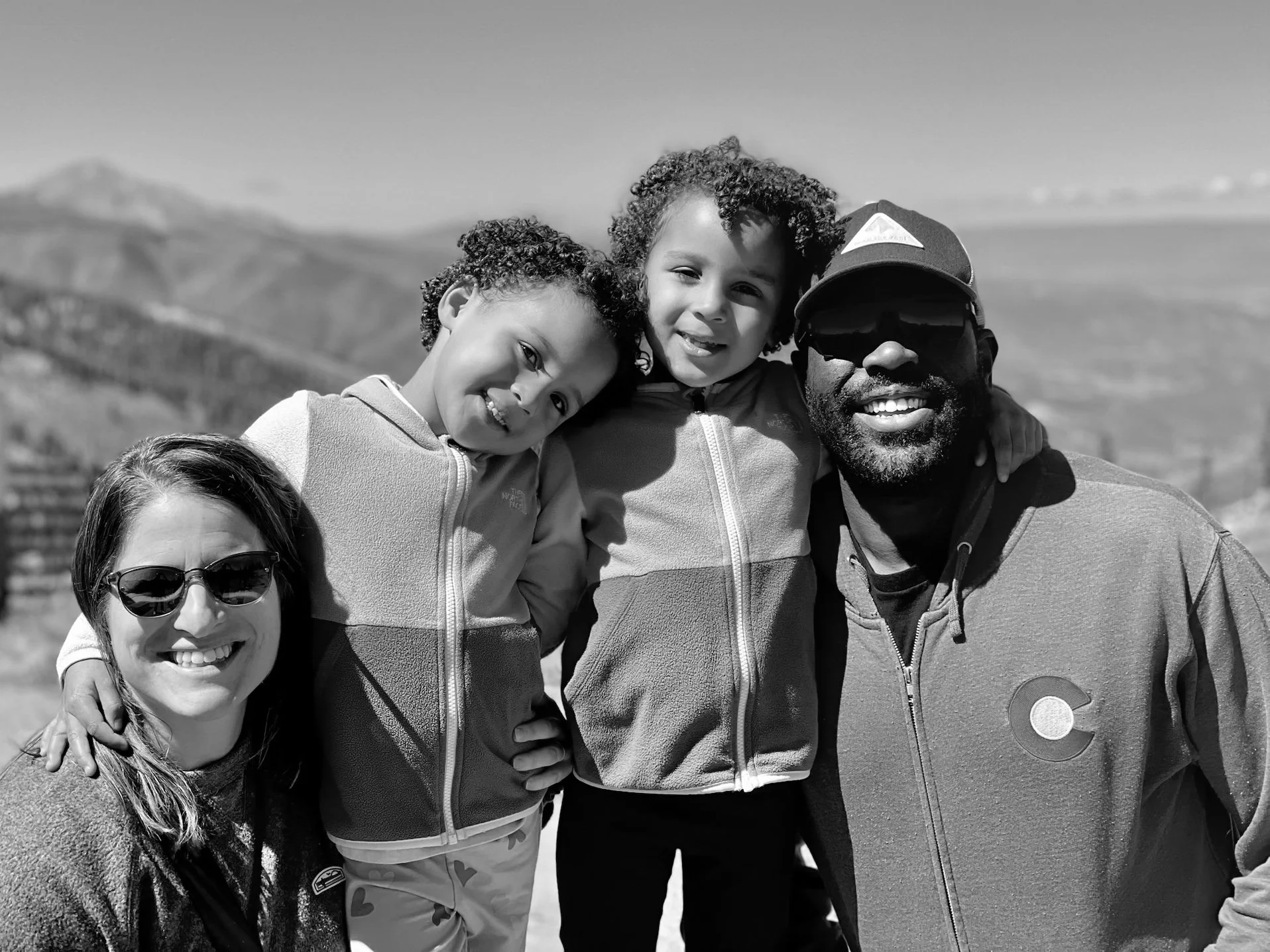 Stacy with her husband and two children in a mountain setting