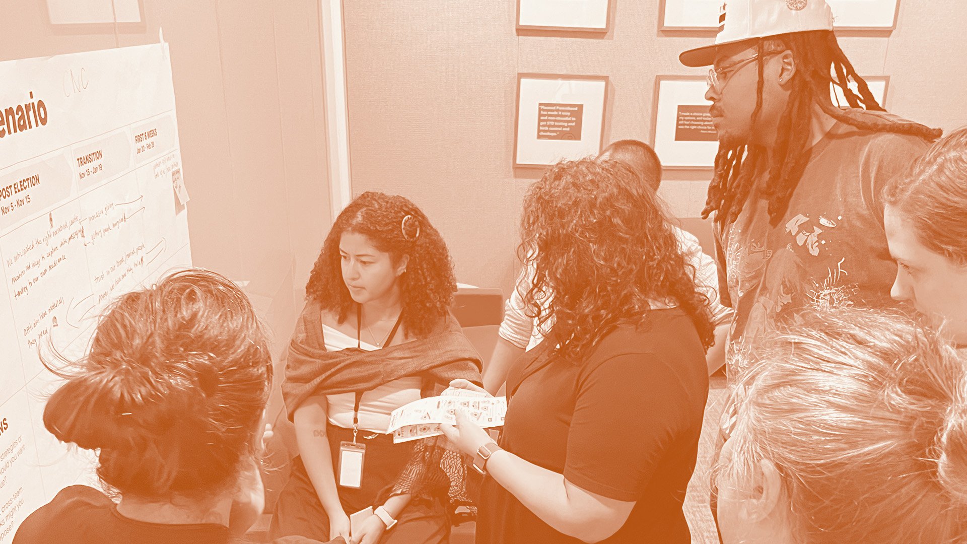 A group of people work together to make notes on a whiteboard for a brainstorm session