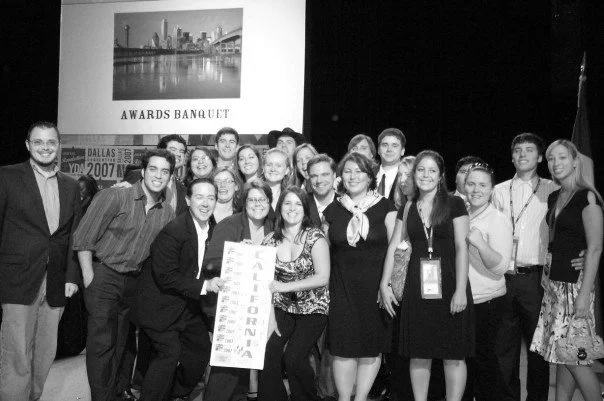 Stacy Berger standing with a group at an awards banquet