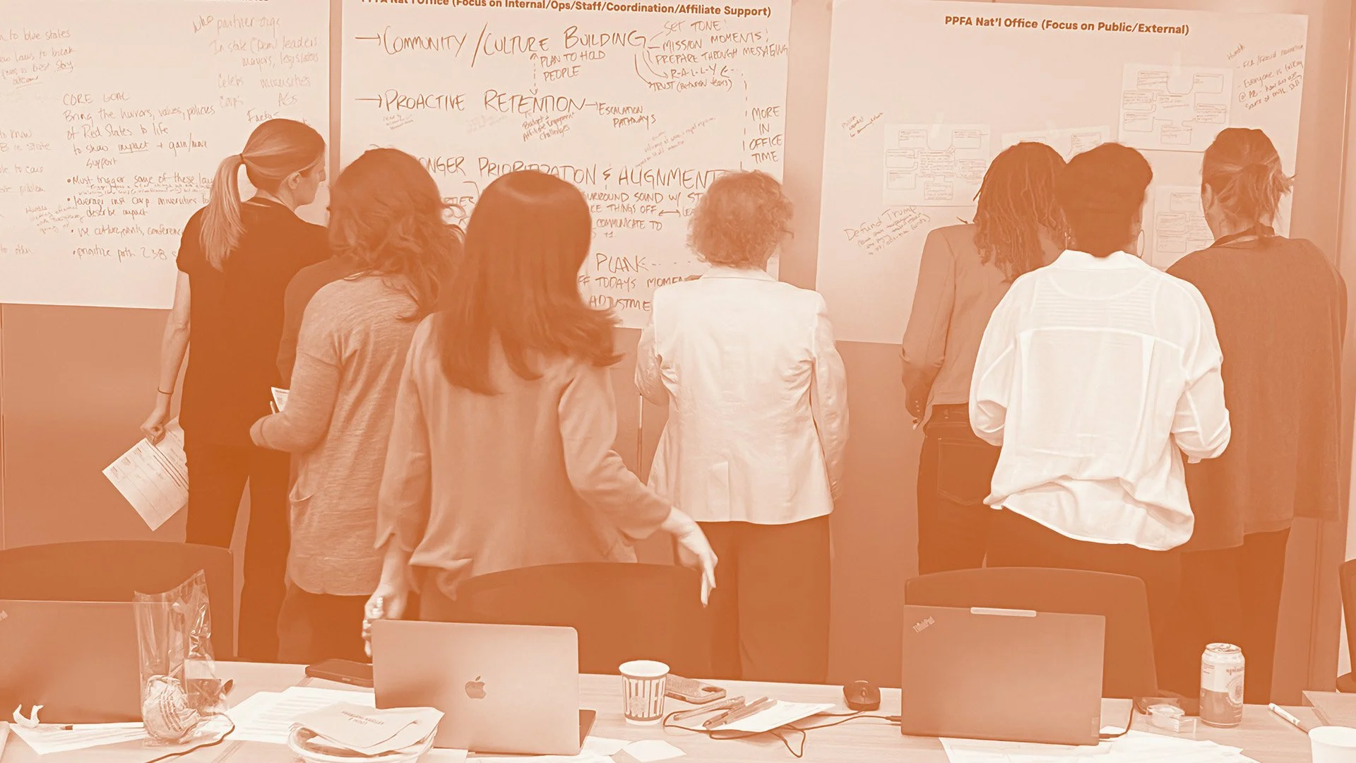 A group of people working together to brainstorm ideas and record them on a whiteboard