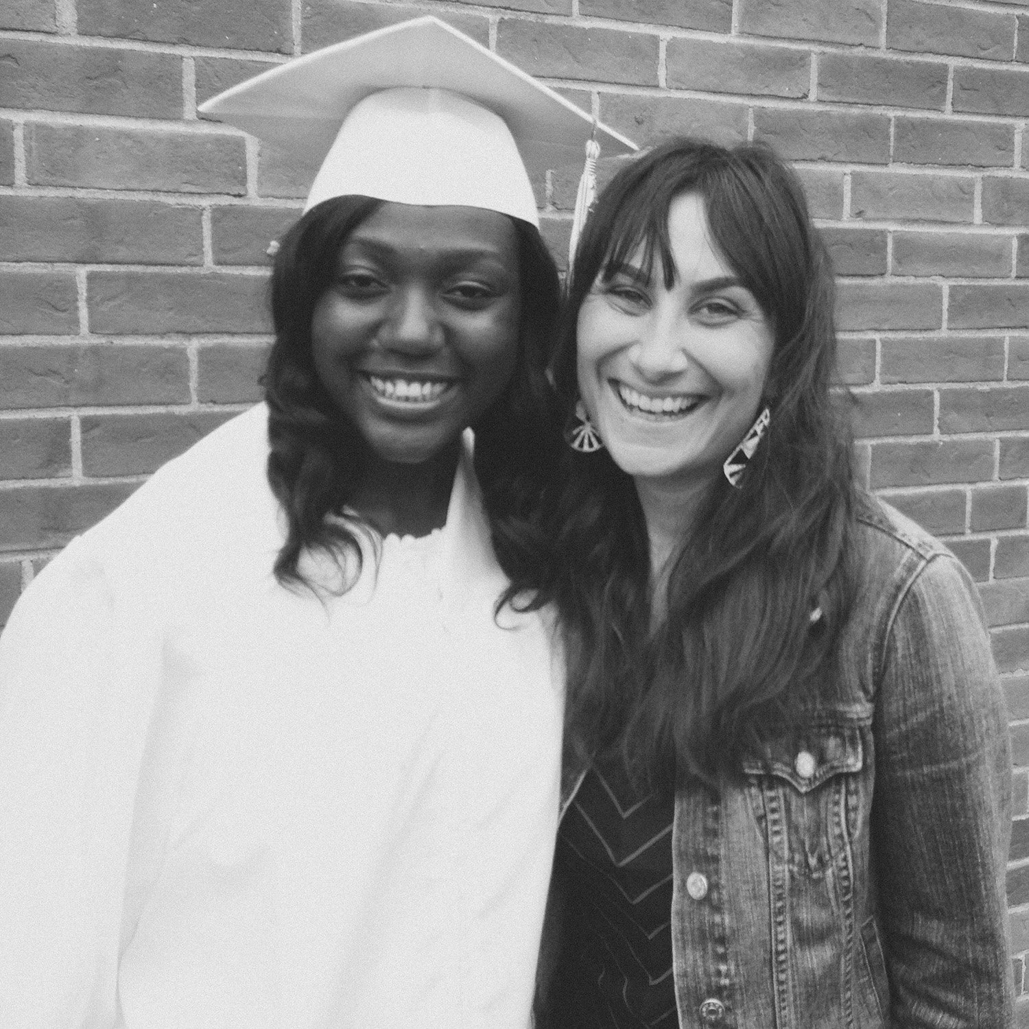 Jenna Shapiro standing with a recent graduate in cap and gown
