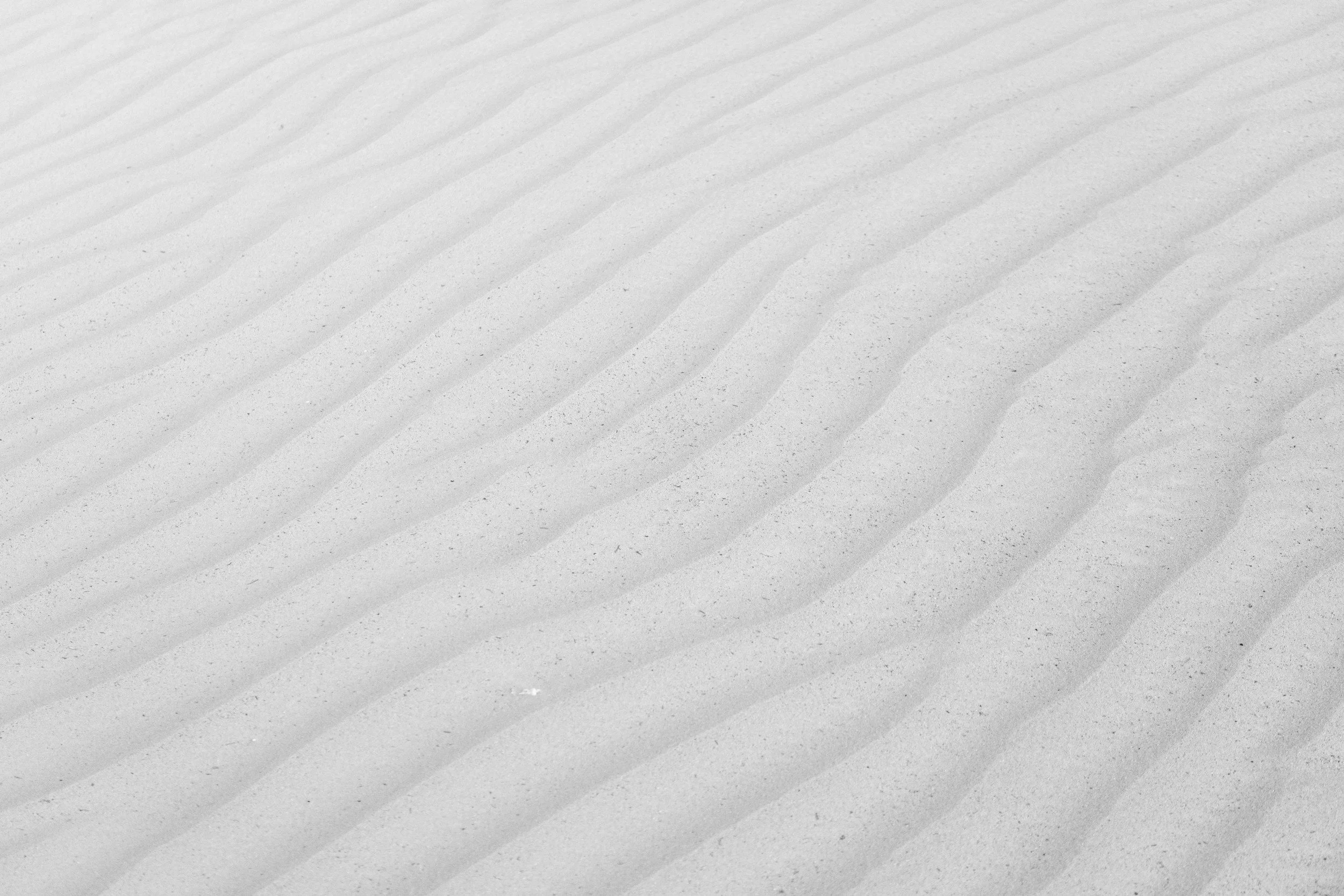 Close-up of white sand with wind-shaped ripples