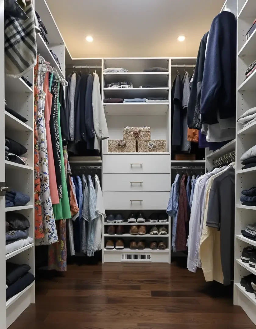 Well-organized walk-in closet with shelves, hanging clothes, shoes, and storage boxes.