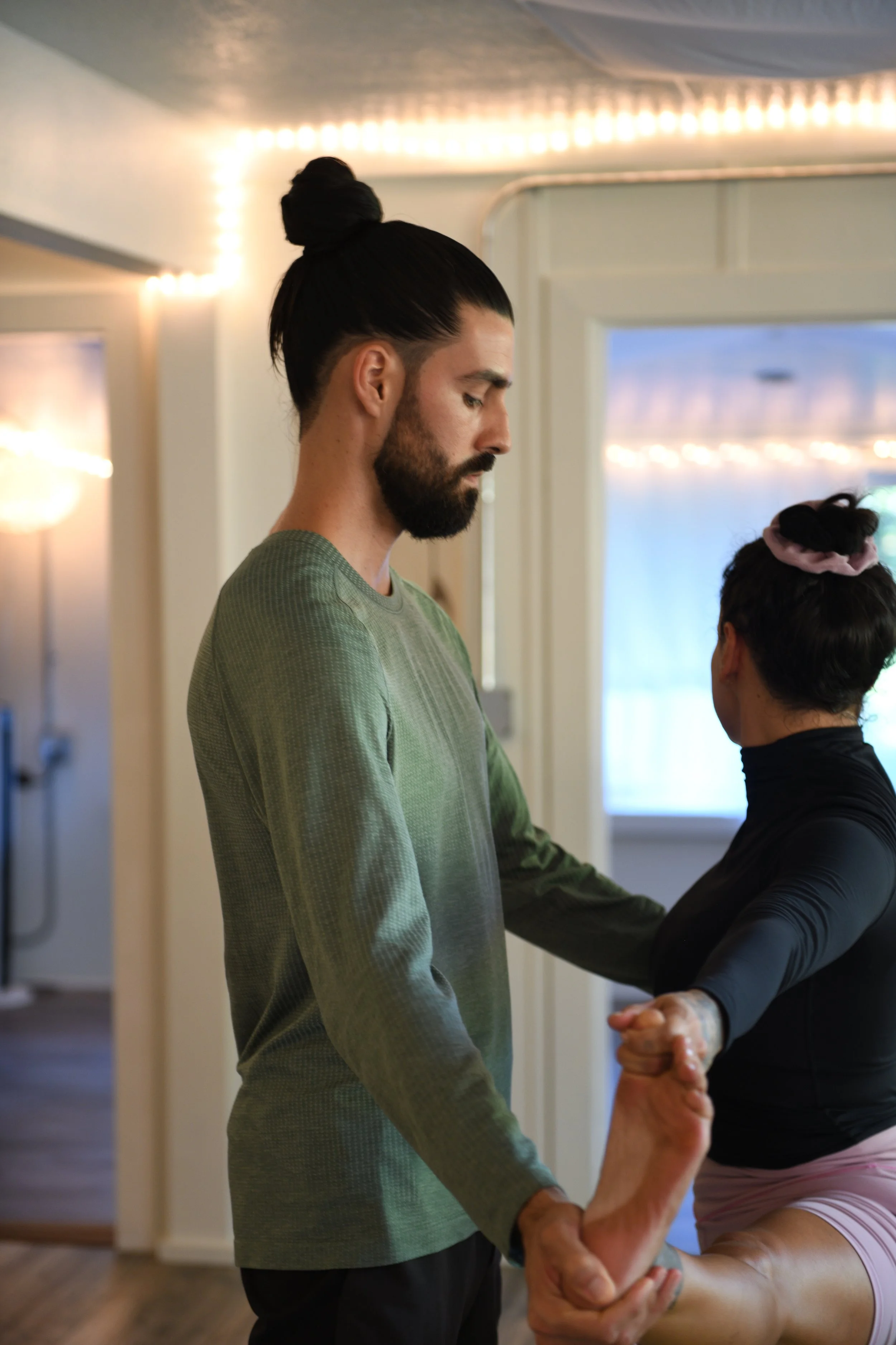 Caio assisting Letícia Soares on Utthitahastapadangustasana 