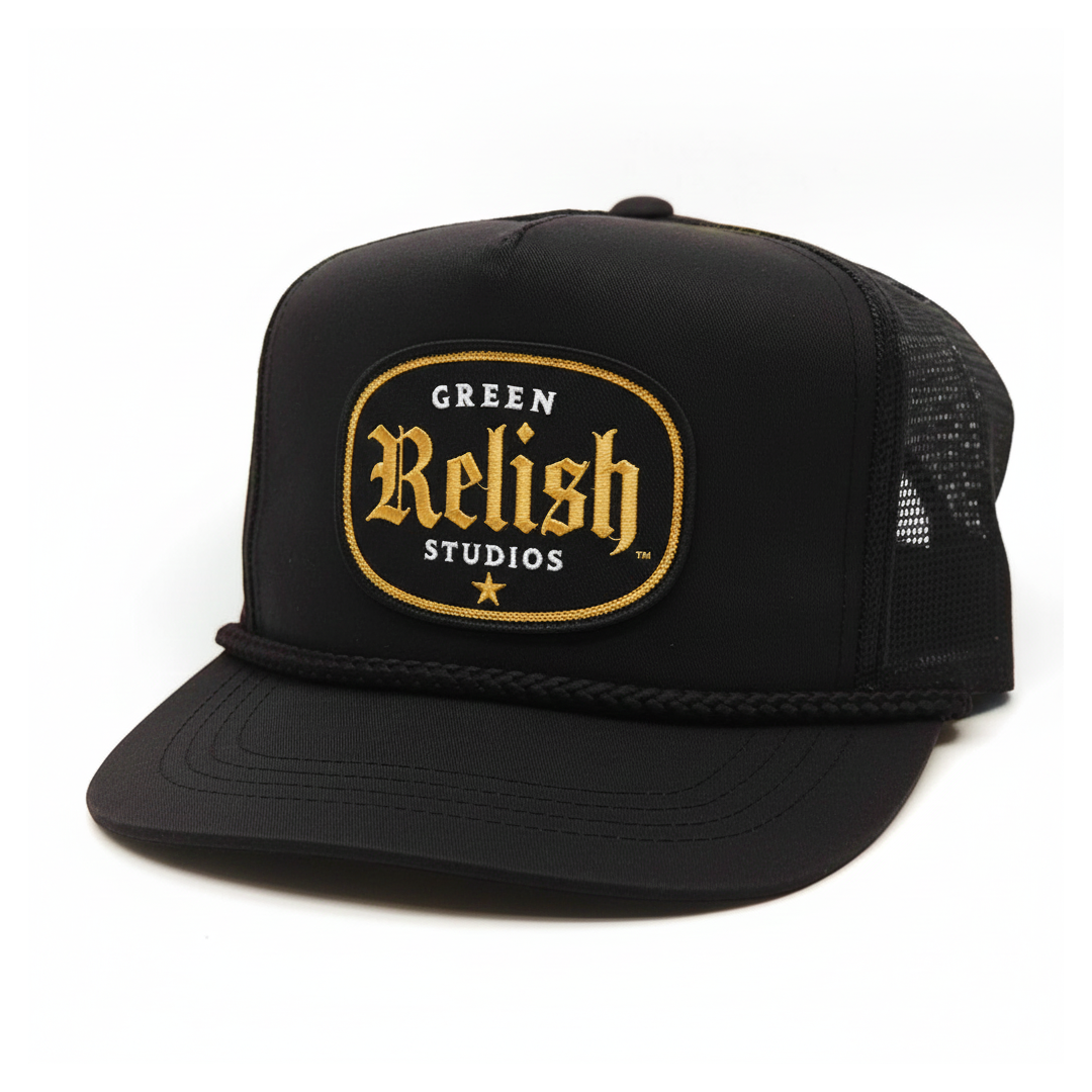 Black trucker hat with a patch reading "Green Relish Studios" in gold and white lettering, featuring a star and mesh back.