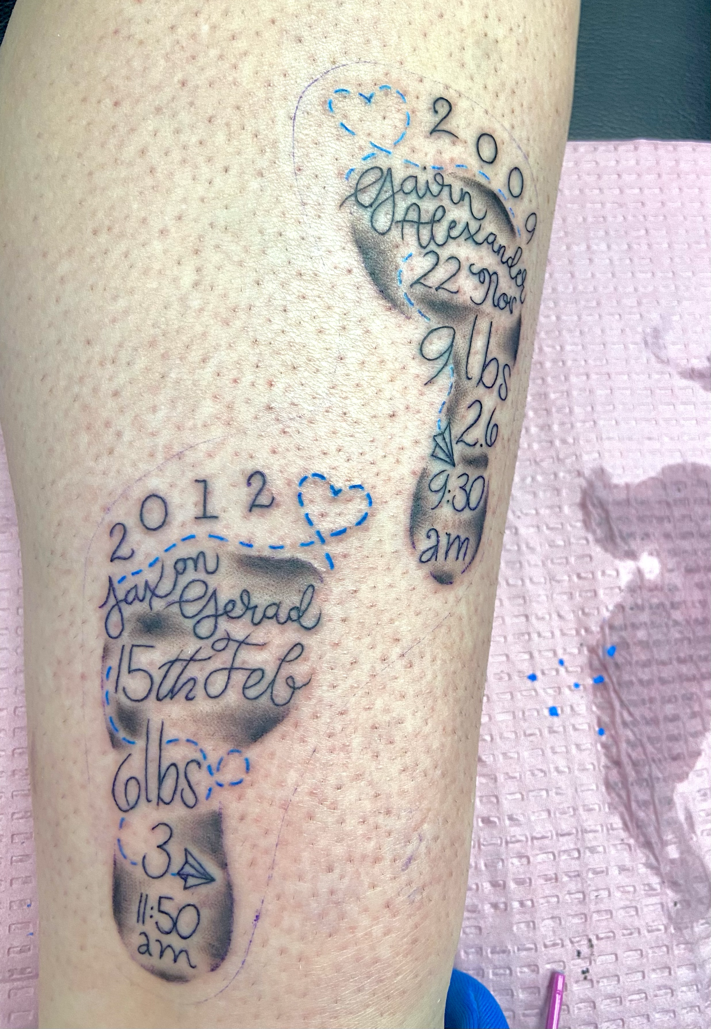 Preliminary tattoo sketch of a birth announcement for a baby girl, including the birth date, time, weight, length, and parents' names, with dotted lines and heart shapes as guides.