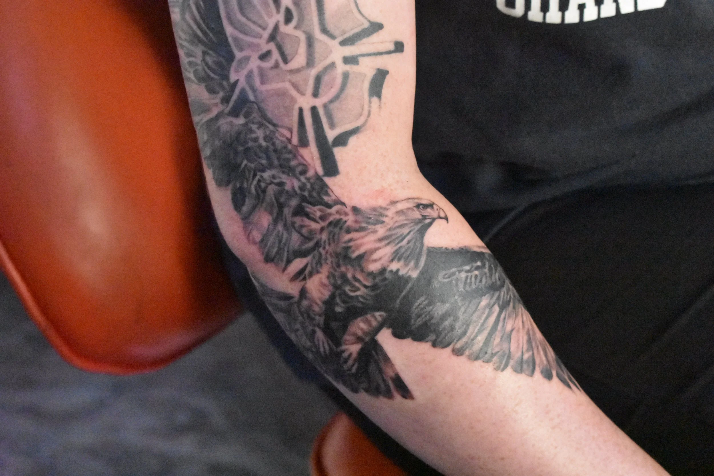 Tattoo of an eagle with a background of a star geometric design on a person's arm.