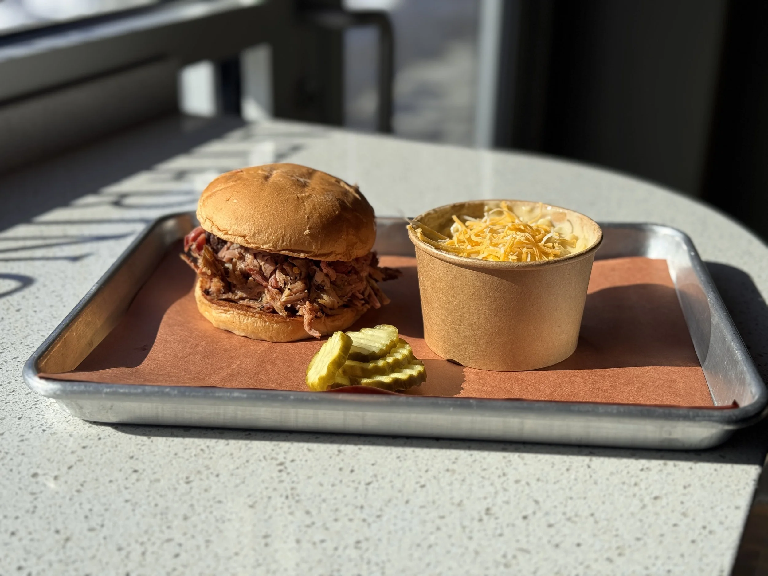 Our slow smoked pulled pork sandwich and a cup of the best Mac & Cheese in Lincoln