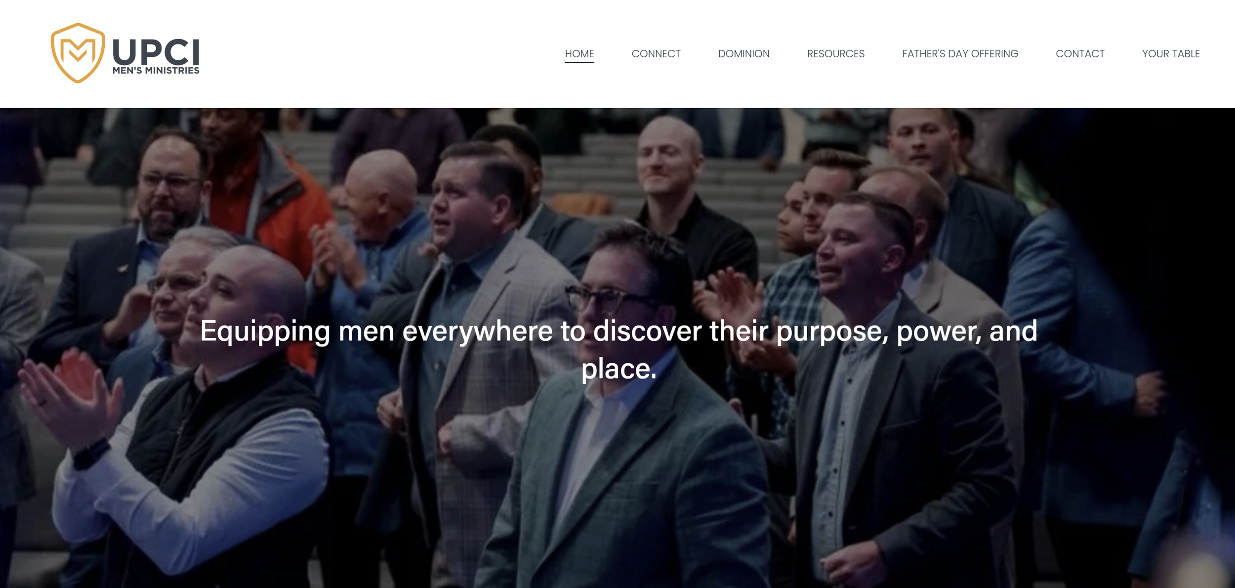 A group of men gathered at a church or conference, some clapping and others standing in applause, with a church-like setting in the background.