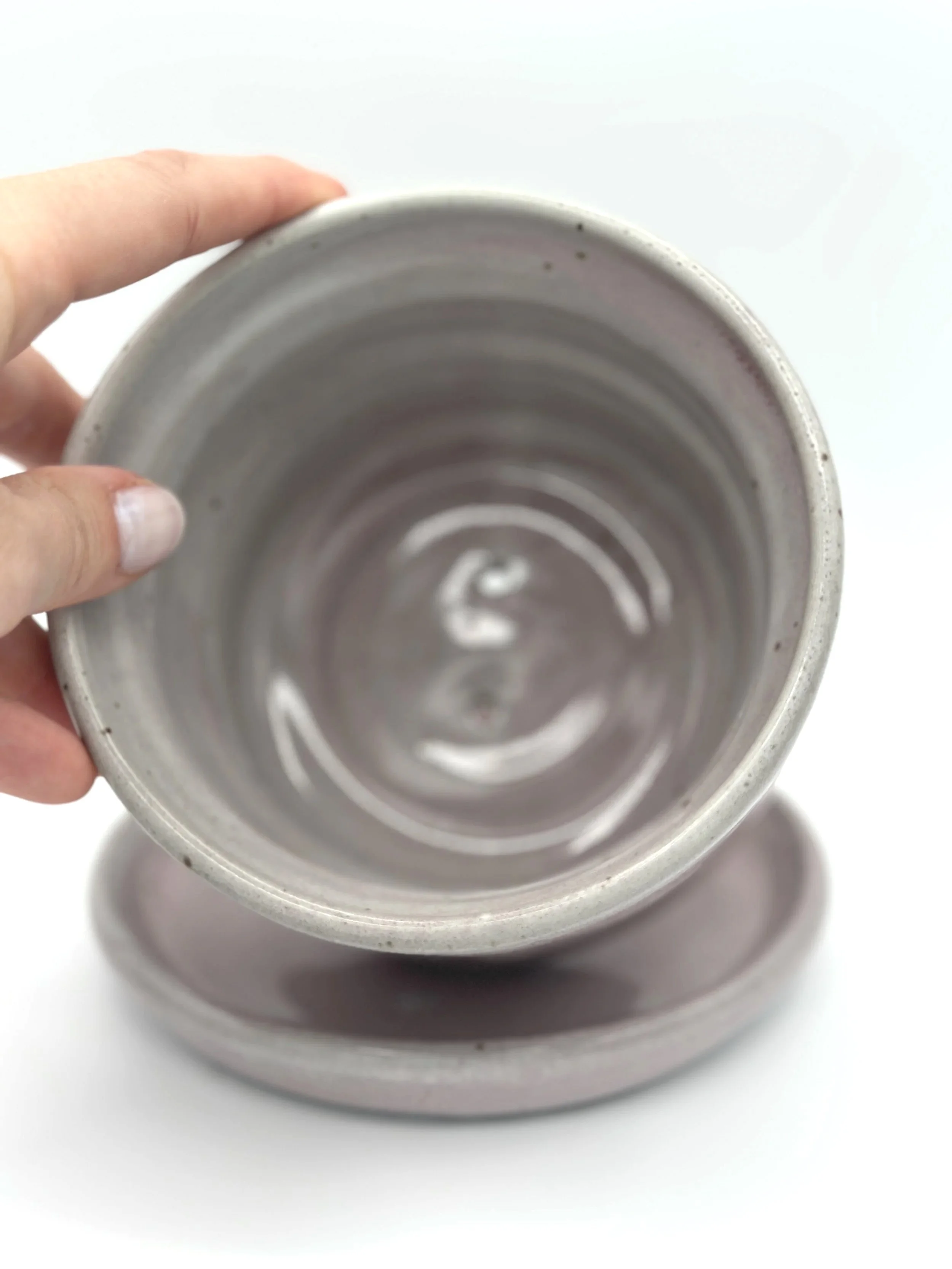 handmade stoneware ceramic bubble planter with 3 waves and a tray in glossy lavender, mauve, pink and grey glaze held by a manicured hand