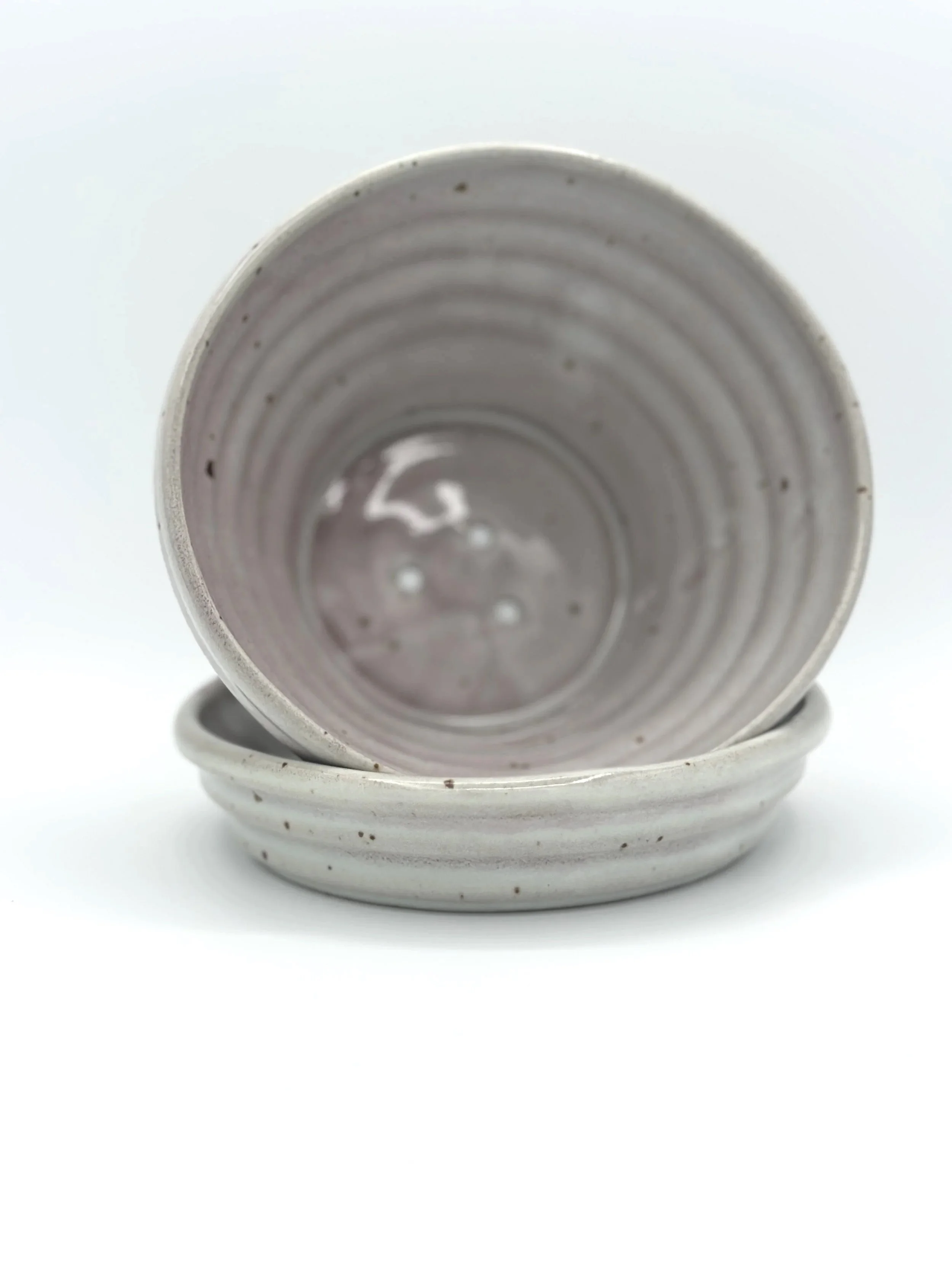 handmade stoneware ceramic planter with ribbed texture and tray. color is a deep mix of grey and pink with lots of motion and variability