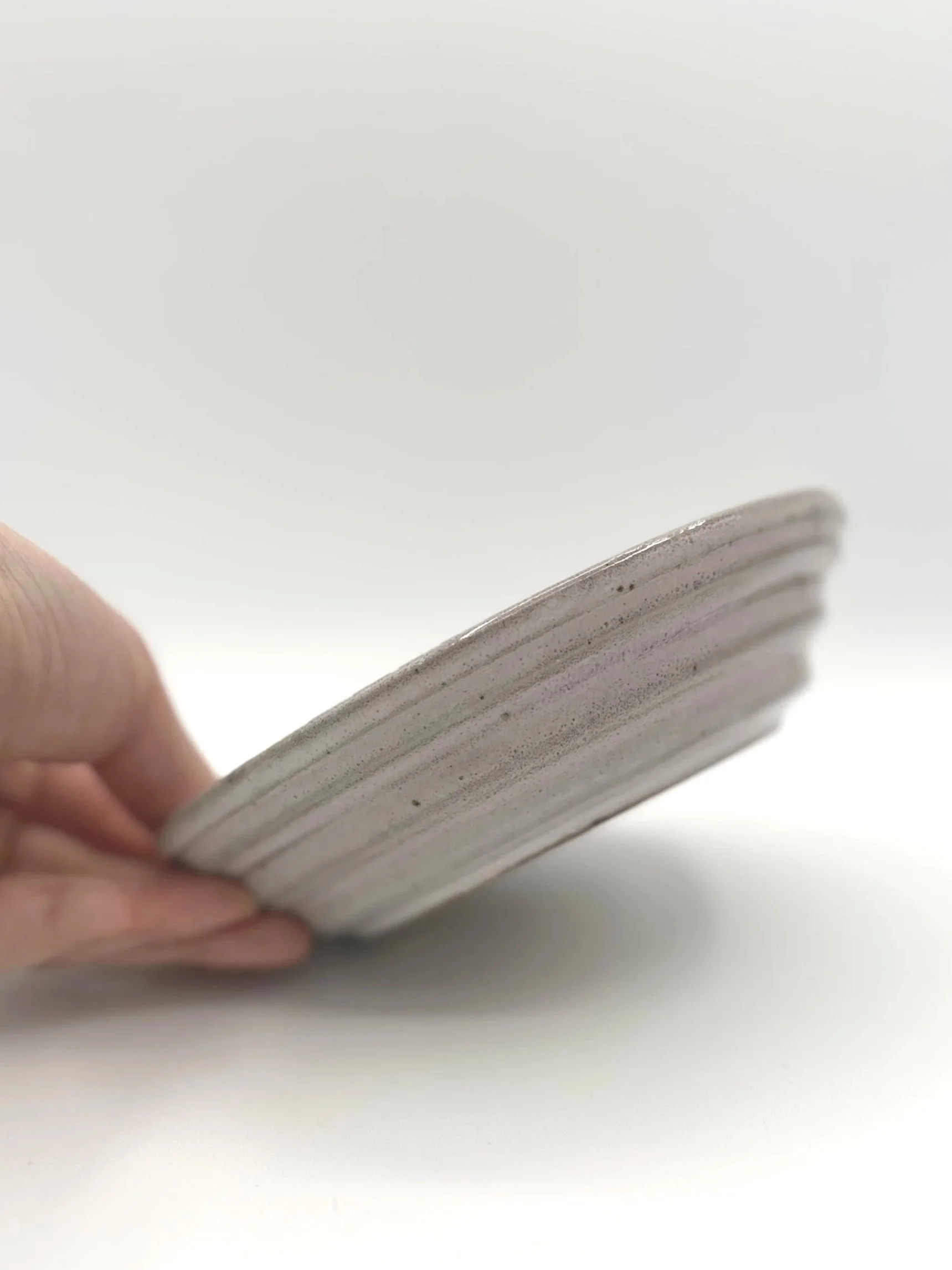 handmade stoneware ceramic planter stepped tray with a manicured hand holding it for display