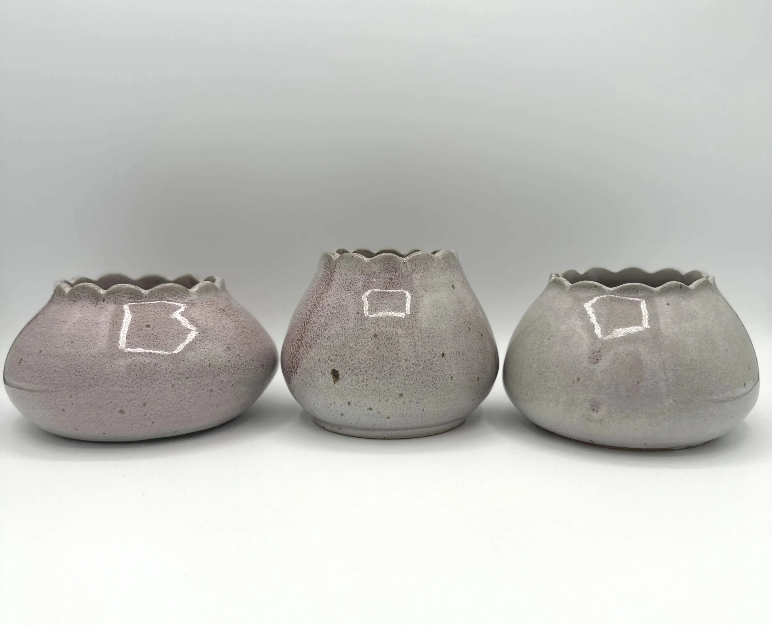 Three handmade stoneware ceramic vases in glossy lavender, mauve, pink and grey glaze with scalloped rims