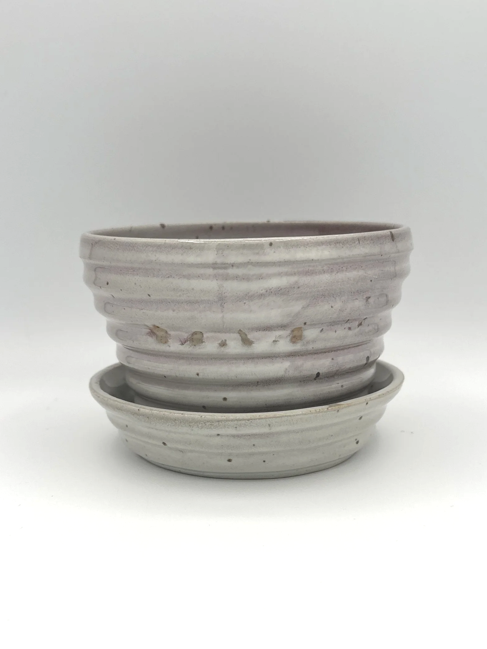 Handmade stoneware ceramic stepped planter and matching stepped tray light pinkish colored shiny candy coated glaze