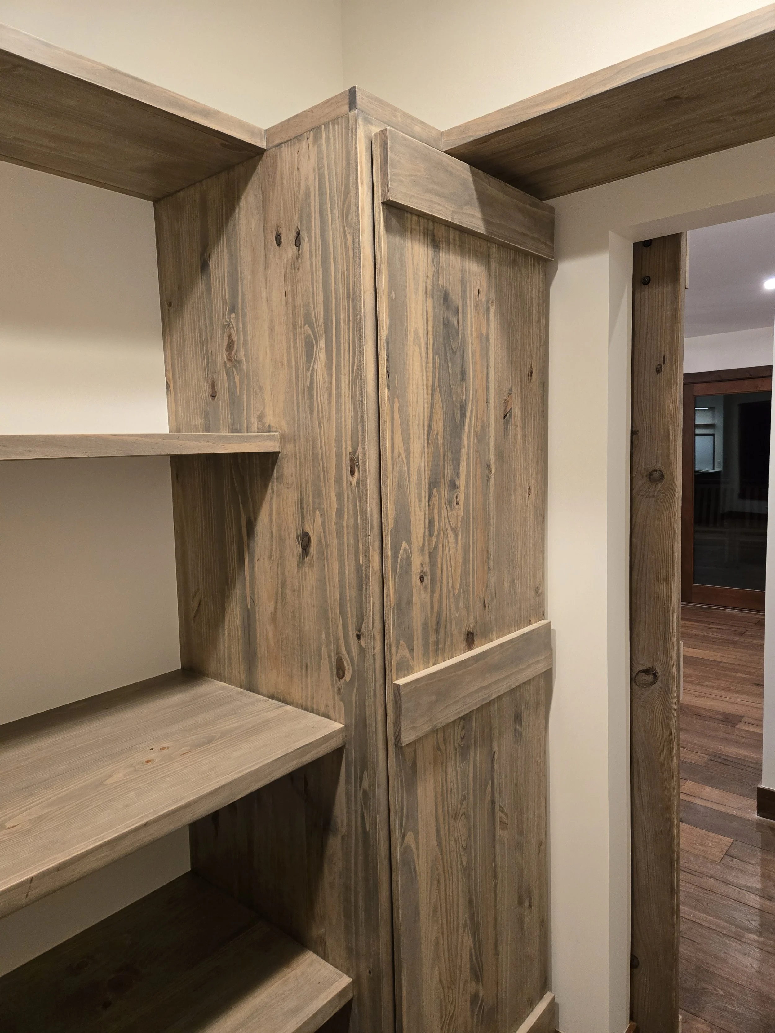 Close-up of a corner with wooden shelves and paneling in a room.