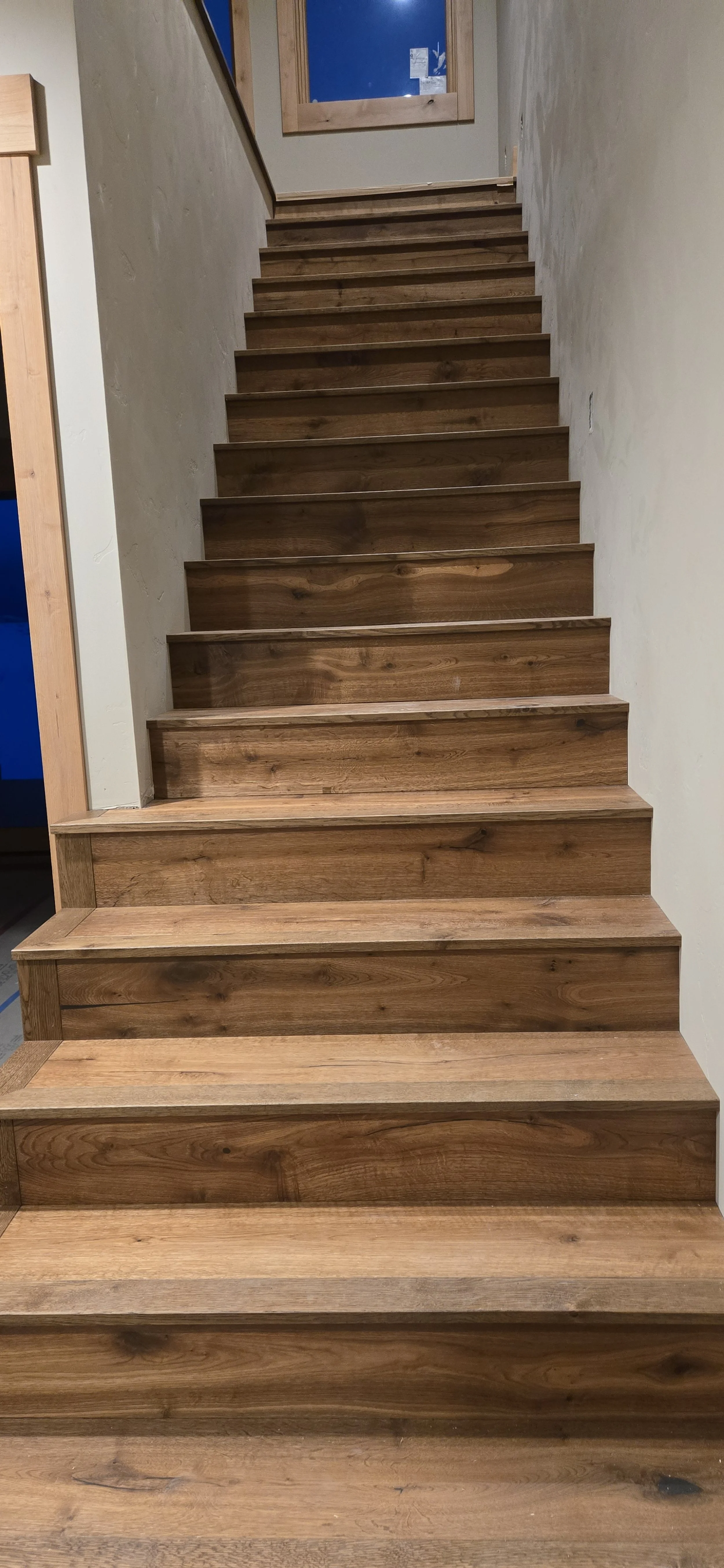 Wooden staircase leading up to a door with a window.