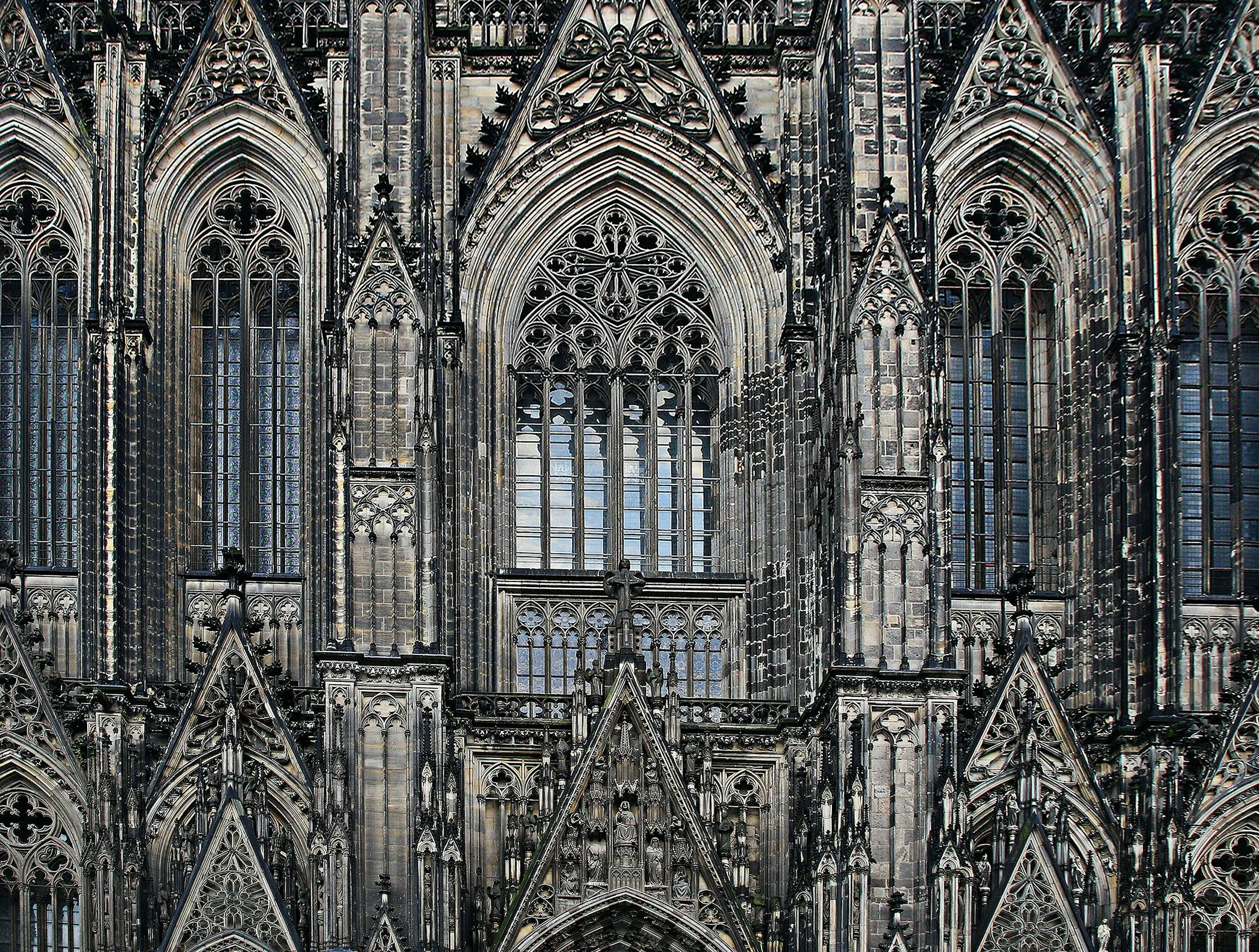 Exterior view of a Gothic cathedral with intricate stonework, pointed arches, and large stained glass windows.