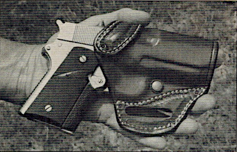 A handgun with a holster resting on a the writers hand.