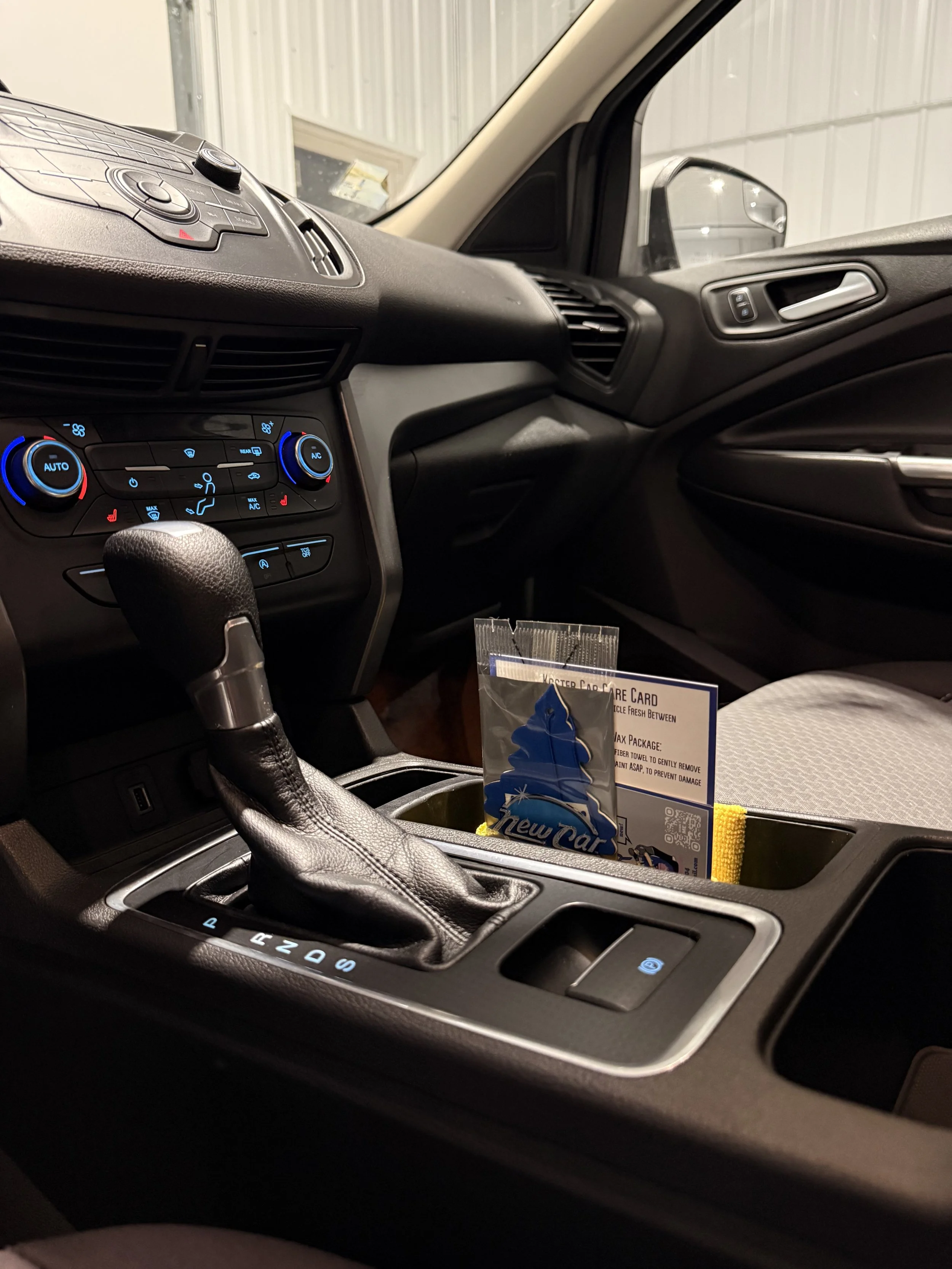 Vehicle interior after professional interior detailing, showing center console and clean surfaces.