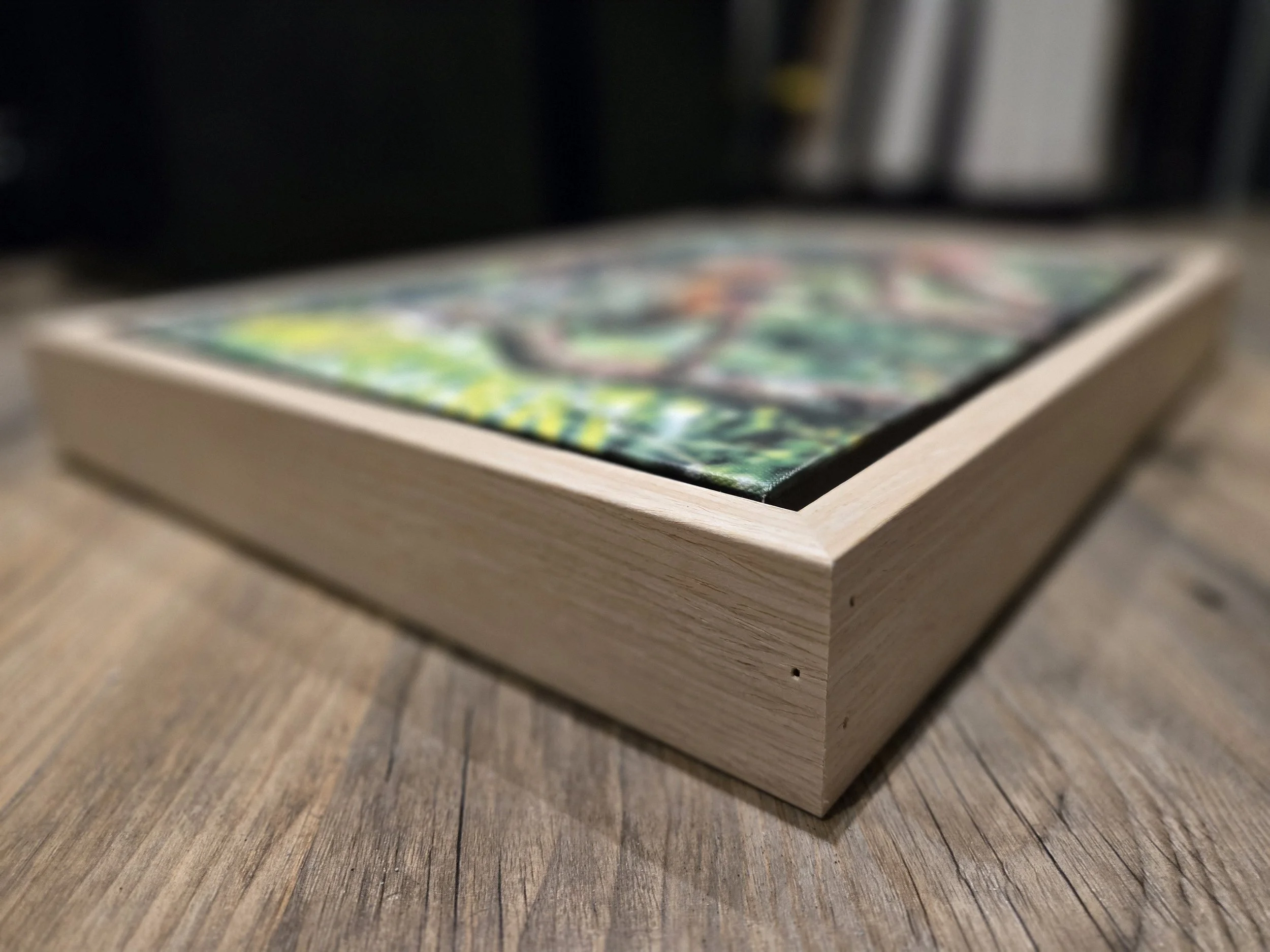 Close-up of a wooden box with a colorful illustration on top, placed on a wooden surface.