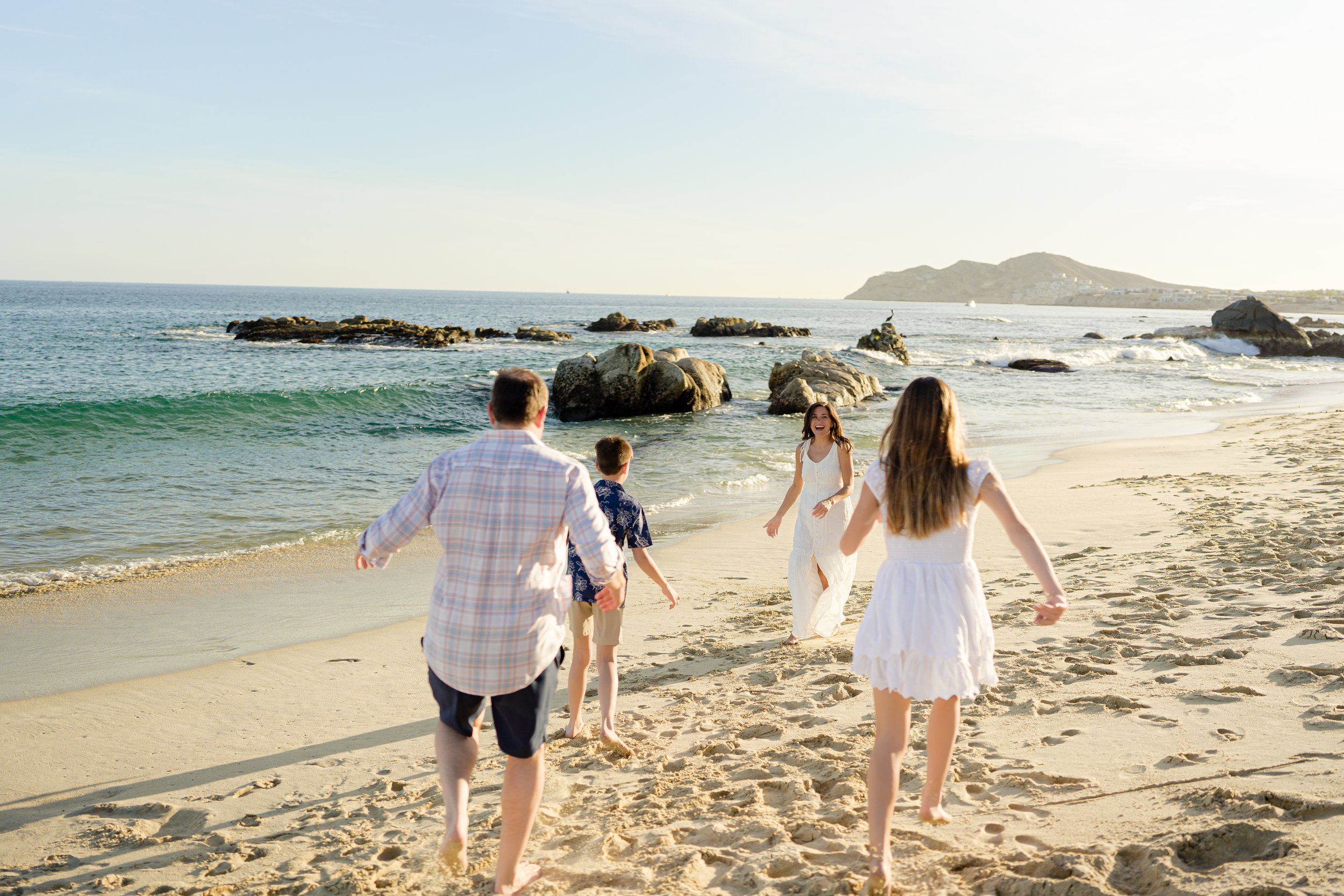 Grupo de personas corriendo en la playa durante el atardecer.