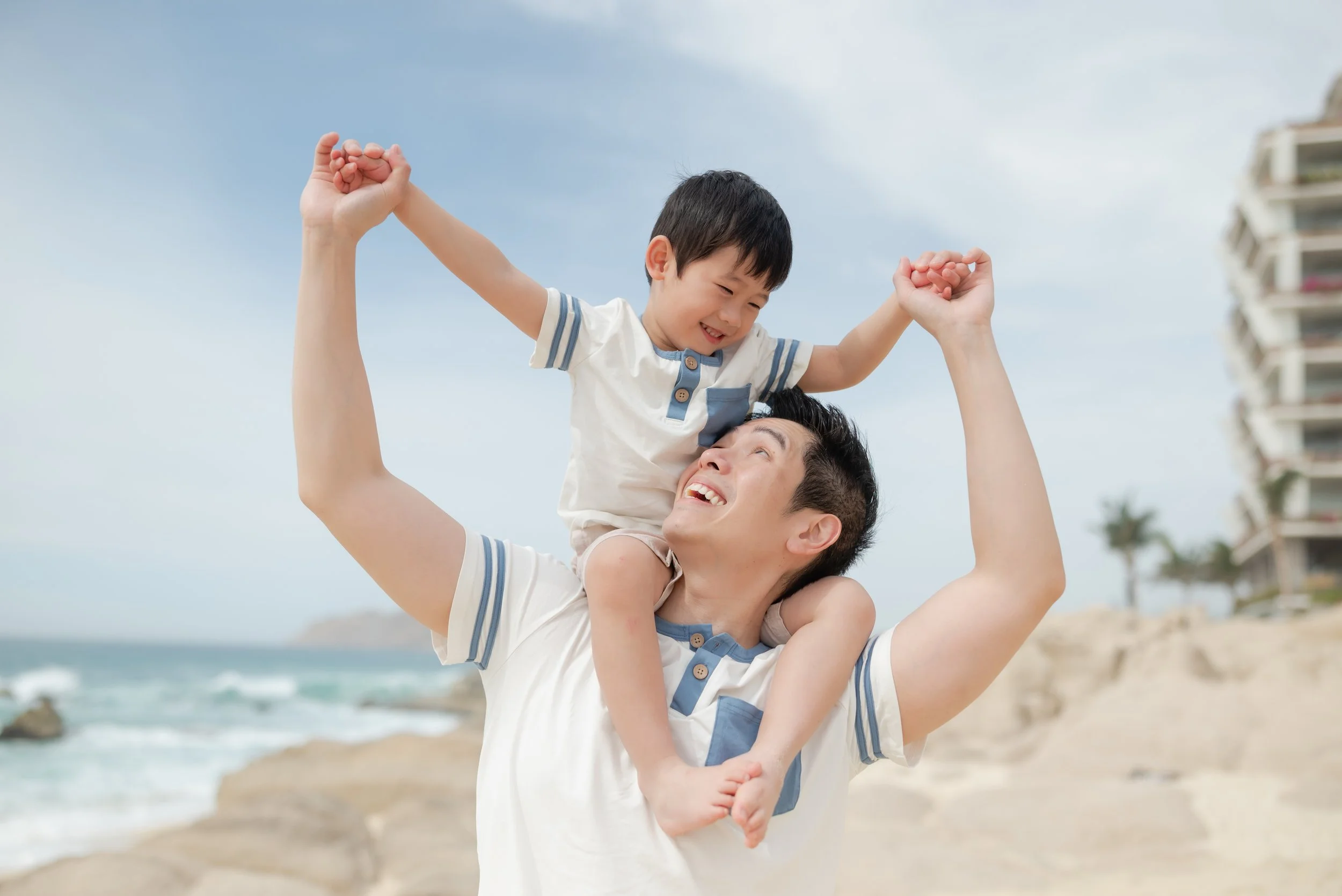 Un padre con un hijo en la playa disfrutando y jugando juntos.