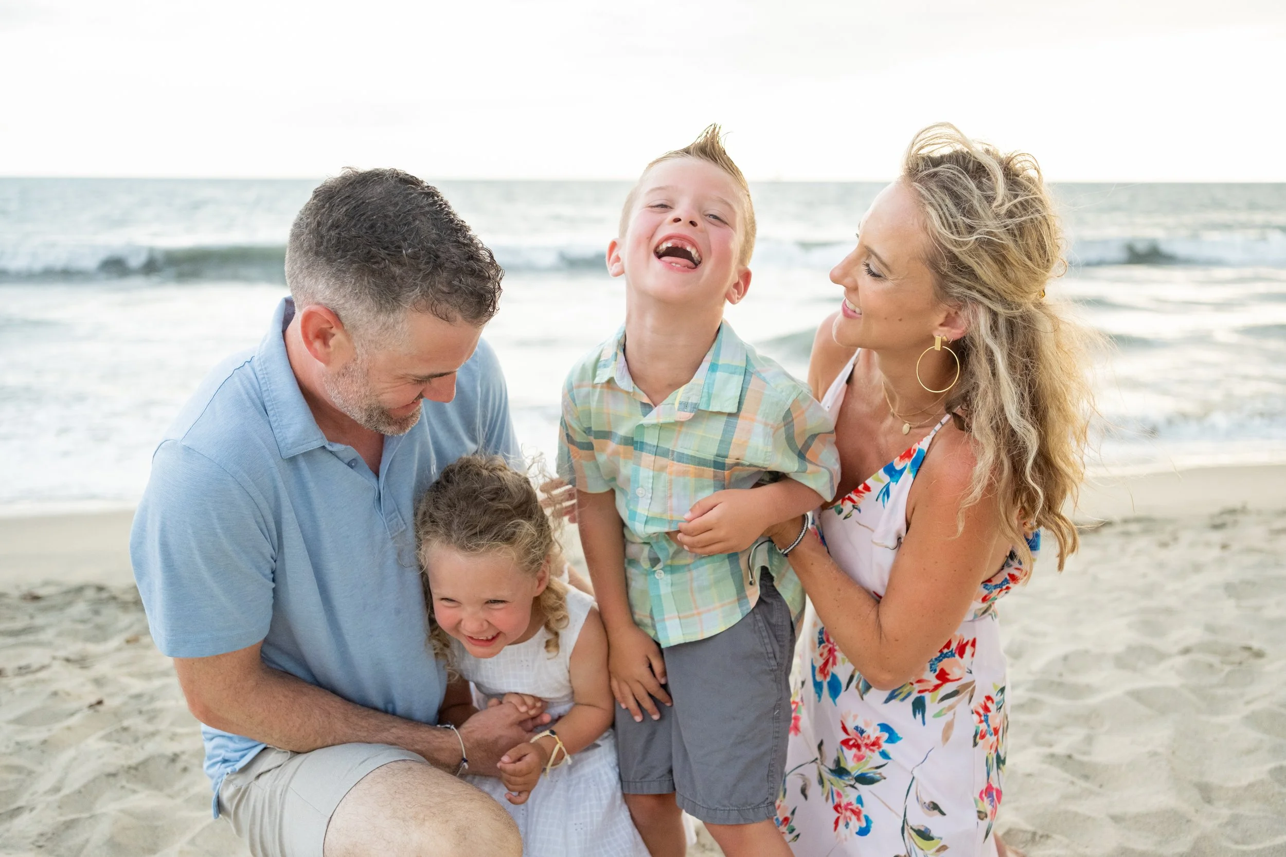 Familia en la playa riendo y disfrutando junto al mar