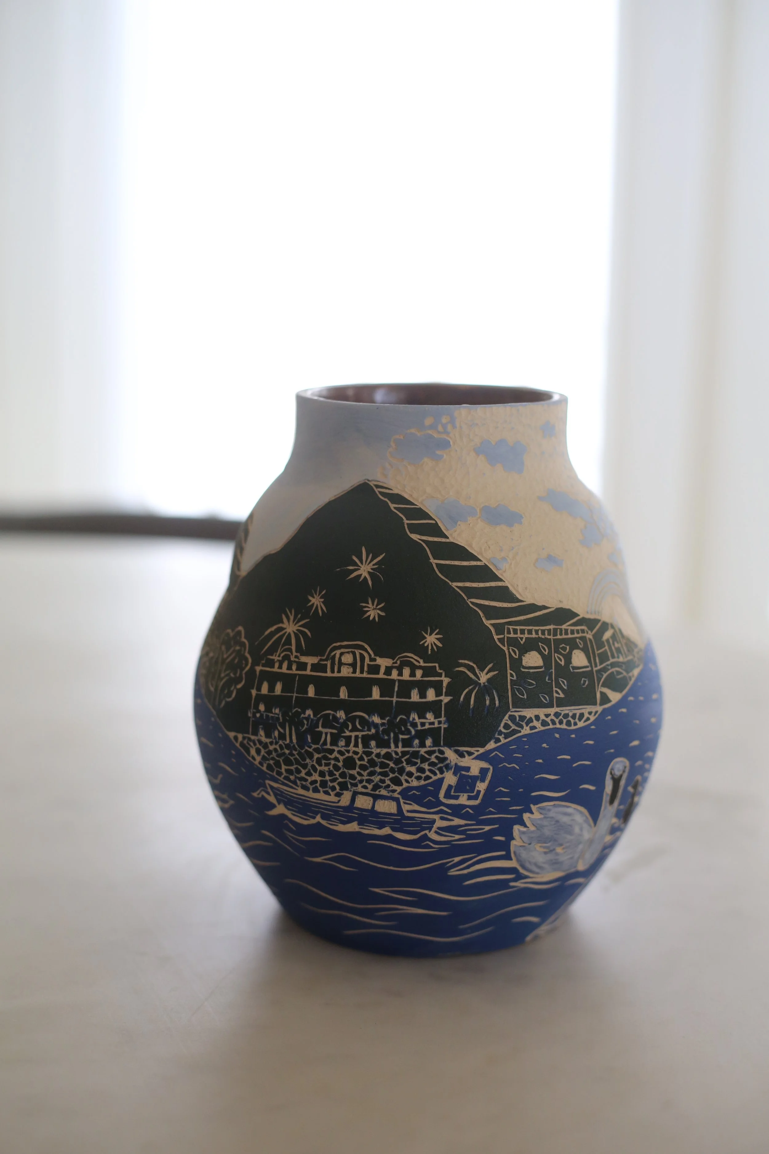 Decorative ceramic vase by Amy Ambrose with a sgraffito illustration of Lake Como featuring clouds, mountains and villas.