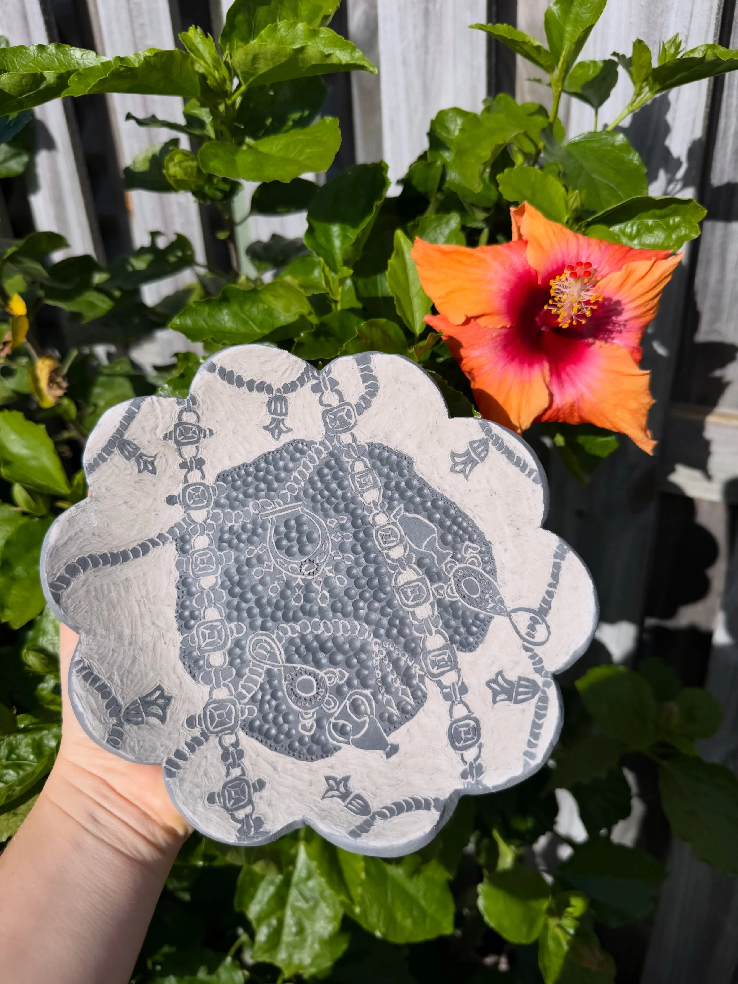 "Bejewelled". A ceramic scalloped plate with jewellery illustrations in sgraffito on it.