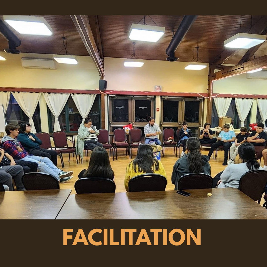 Facilitated group discussion with participants seated in a circle inside a community hall, creating a shared space for dialogue and engagement.