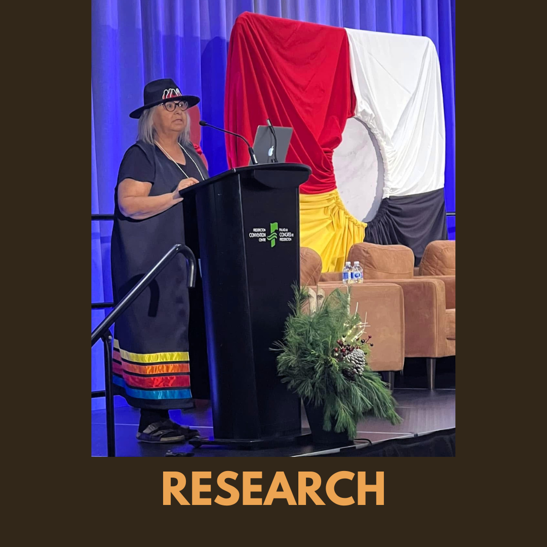 Research presentation delivered at a conference, showing a speaker at a podium with visual materials and Indigenous cultural elements in the background.