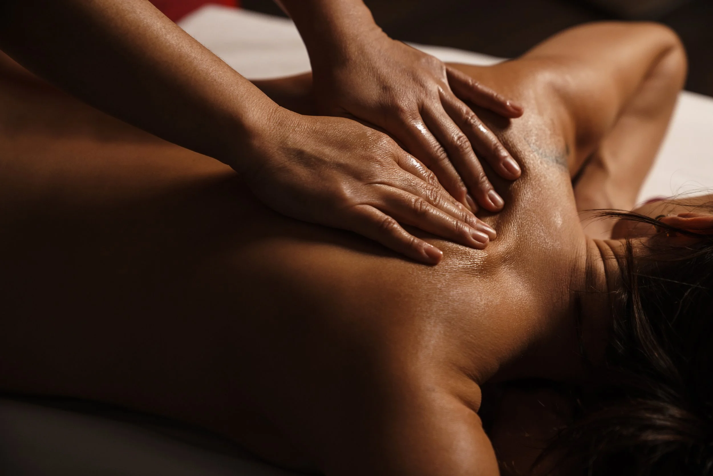 A person receiving a massage on their back from a massage therapist.