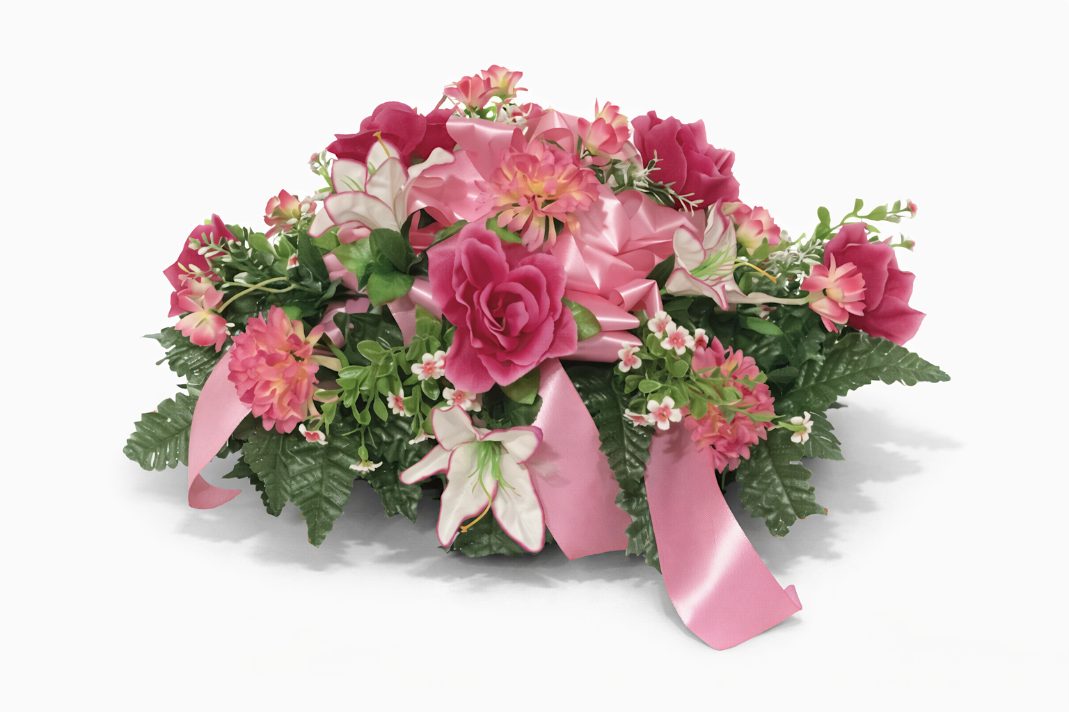 Pink and white artificial flower arrangement with roses, lilies, and greenery, tied with a pink satin ribbon.
