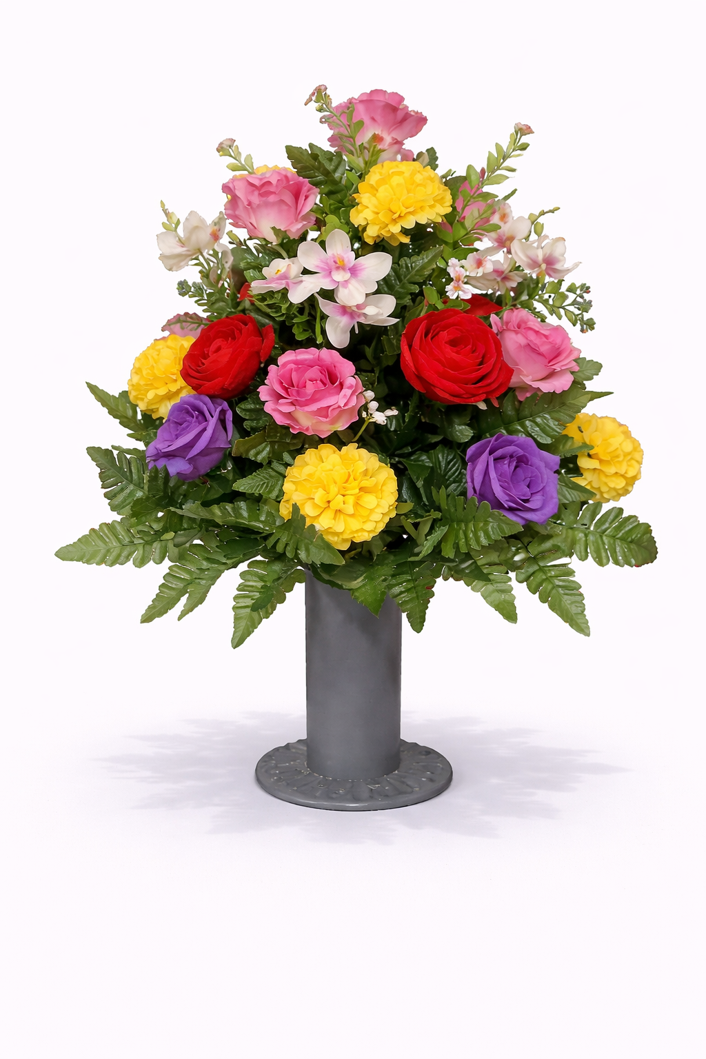 Colorful flower arrangement with red, pink, yellow, purple, and white flowers in a gray vase against a plain background.