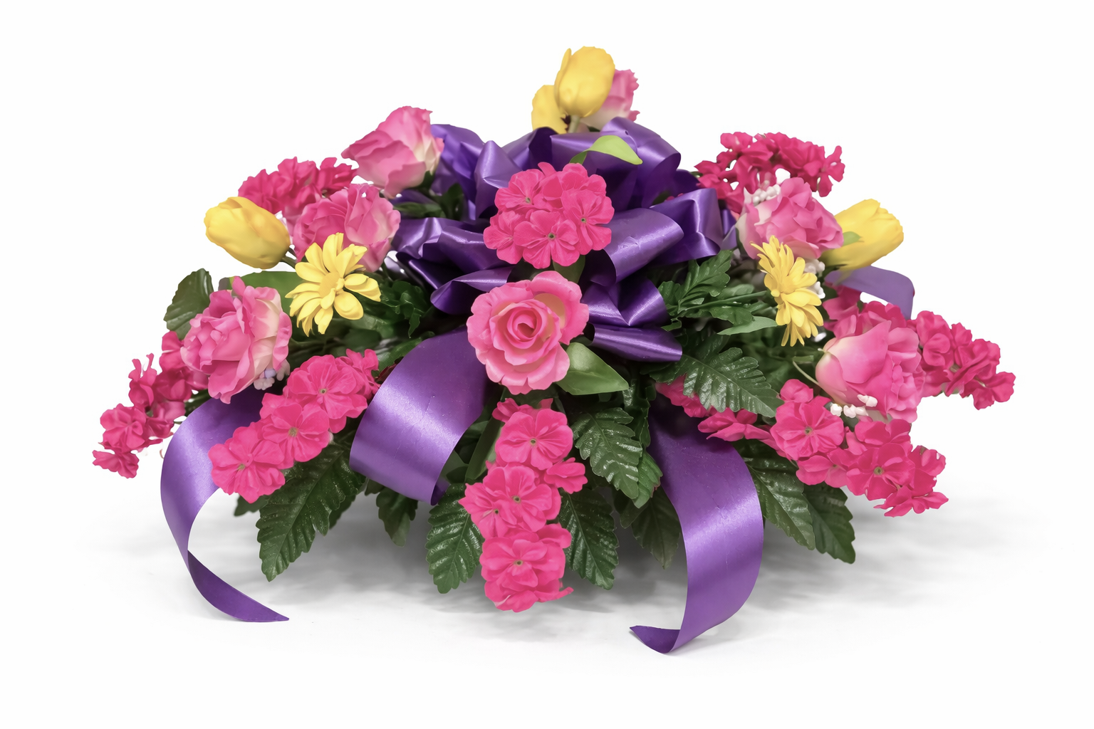 Colorful floral arrangement with pink, yellow, and purple flowers, green leaves, and purple ribbon on white background.