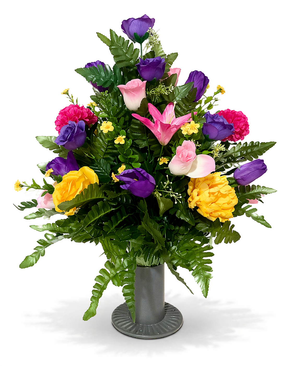 A bouquet of colorful flowers in a gray vase, including pink lilies, purple tulips, yellow carnations, pink roses, and small yellow filler flowers, arranged with green fern leaves on a white background.