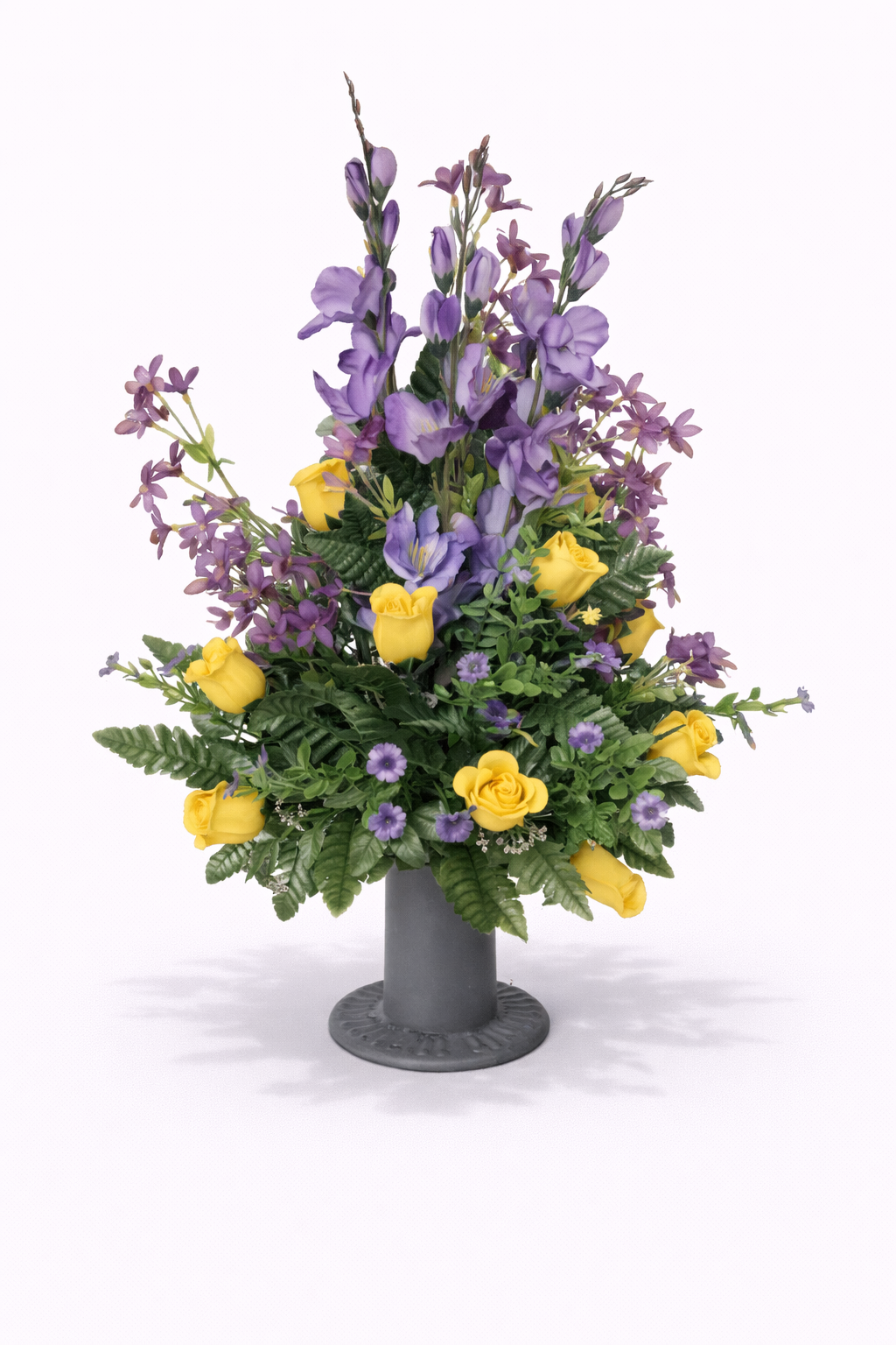 A colorful artificial flower arrangement featuring purple and yellow flowers in a gray vase.