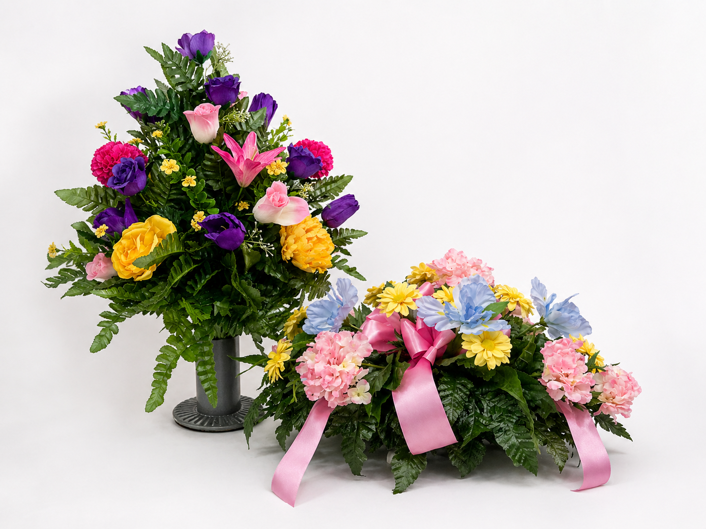 Colorful flower arrangements with pink, purple, yellow, and blue flowers, decorated with pink ribbons, set against a white background.