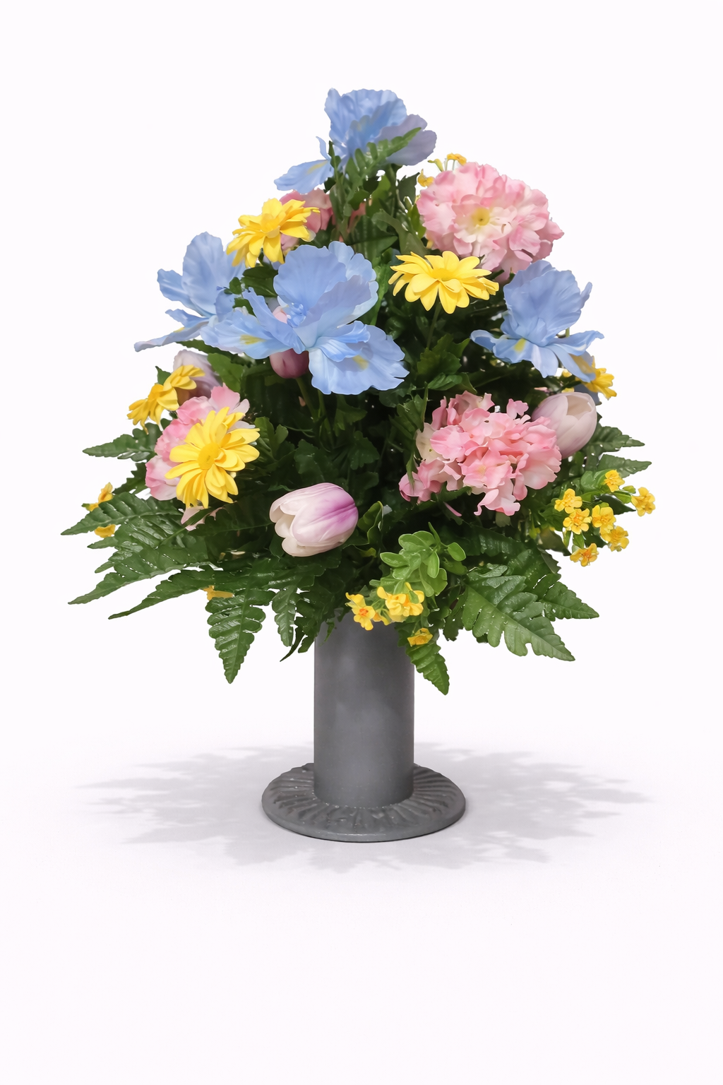 Colorful bouquet of pastel pink, blue, and yellow flowers in a gray vase.