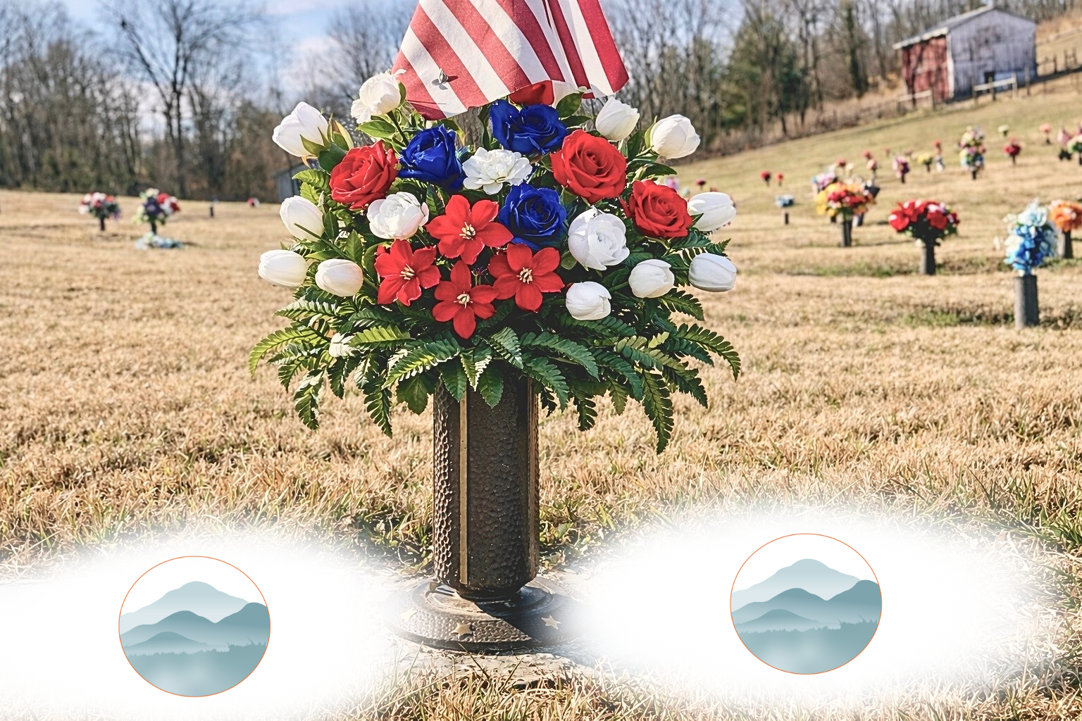 A memorial flower arrangement with red, white, and blue flowers topped with an American flag, placed in a black vase on a grassy field with other flowers in the background.